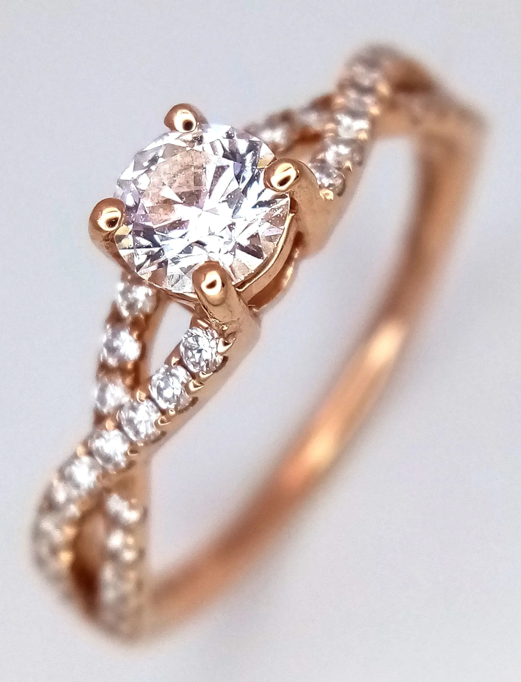 An 18K Rose Gold and Diamond Crossover Ring. 0.33ct round brilliant cut centre stone with 0.40ctw of pave-set diamond crossover shoulders. Diamonds having G colour and SI1 clarity. Size L. 2.5g total weight. MT17.