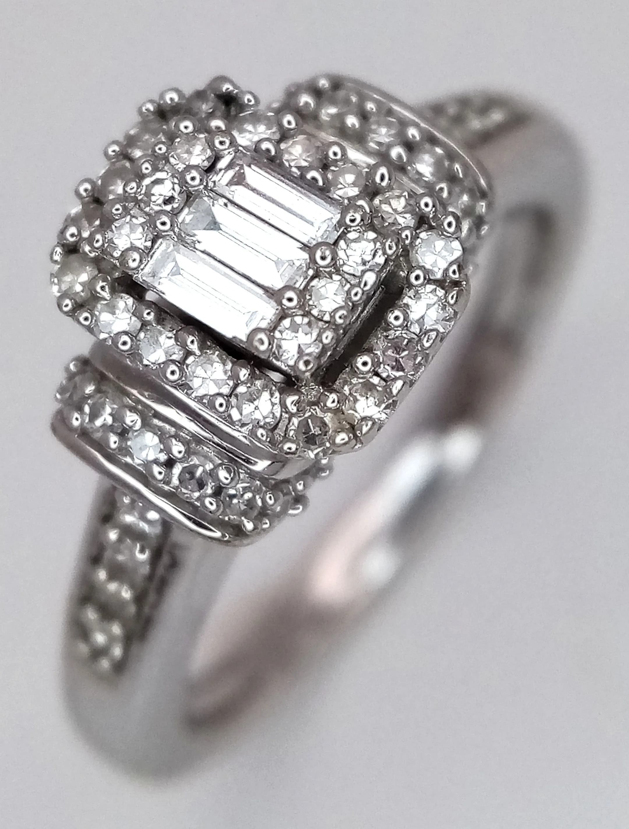 A 9K White Gold and Diamond Art Deco Style Ring. 0.33ctw of baguette and round brilliant cut diamonds. Size K 1/2. 3.9g total weight. Ref: 029552.