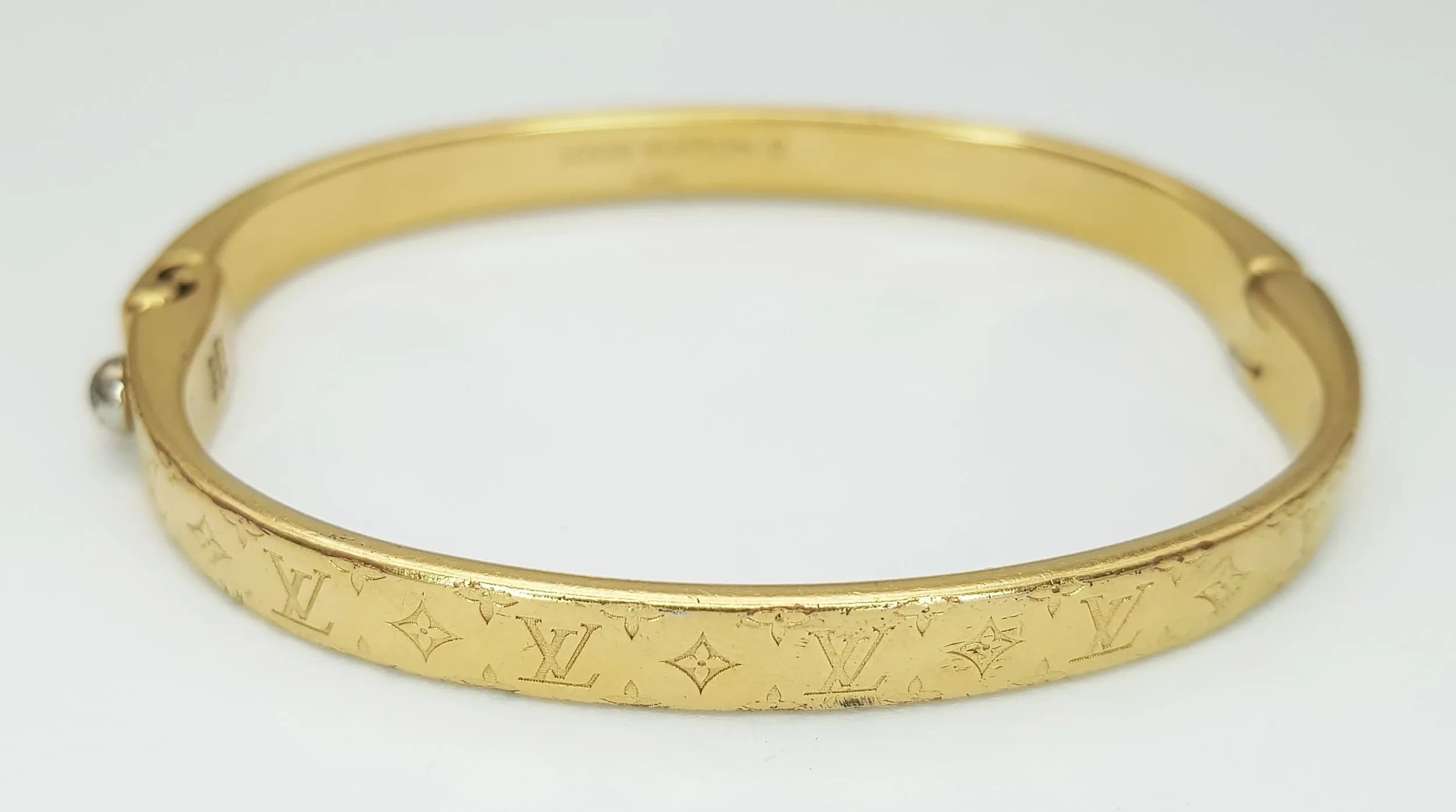 A Louis Vuitton Gilded Monogram Bracelet. Clip open design. 52mm inner diameter. Ref: 028918