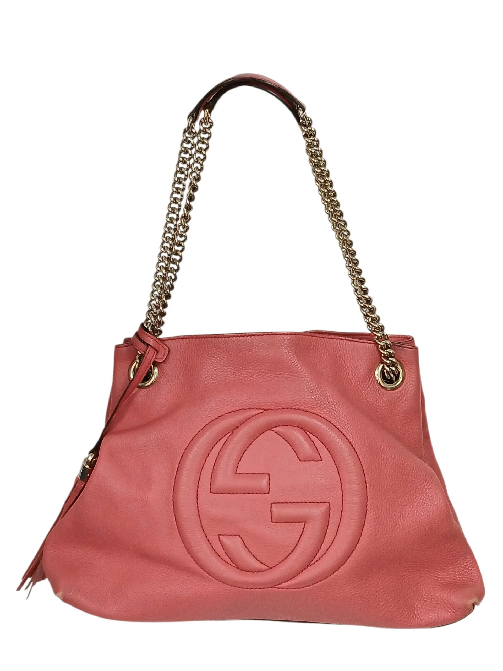 A Coral Pink Gucci Soho Chain Tote Bag. Coral pink leather exterior with gold-toned hardware, leather shoulder straps, and lobster clasp closure. Beige leather interior with one main compartment, zip and slip pockets. Approx. 37cm length x 25cm height x 11cm depth. Comes with a dust bag and Certificate of Authenticity. Some signs of wear and marks to the leather. Please see photos or request a condition report. Ref: 29370.