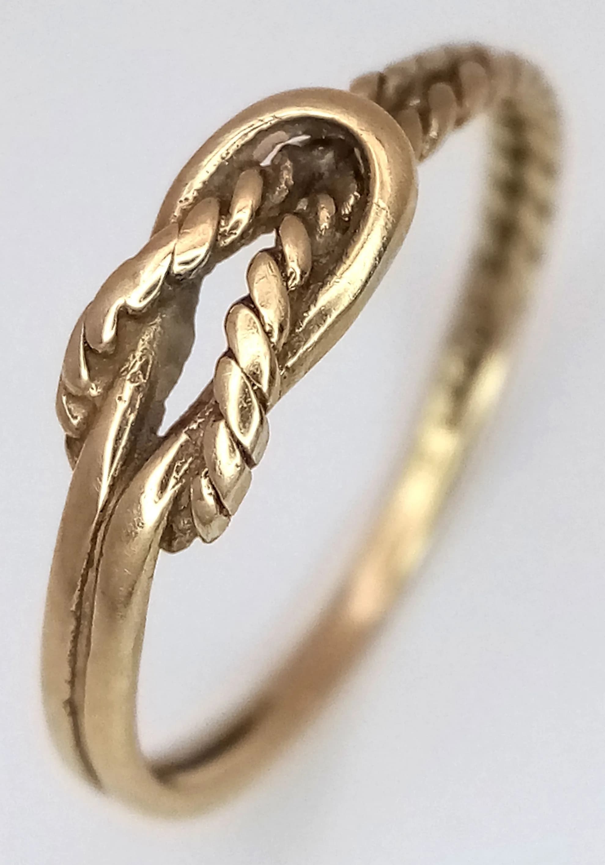 A 9K Yellow Gold Thin Band Ring with Knot Centre. Size G. 0.7g.