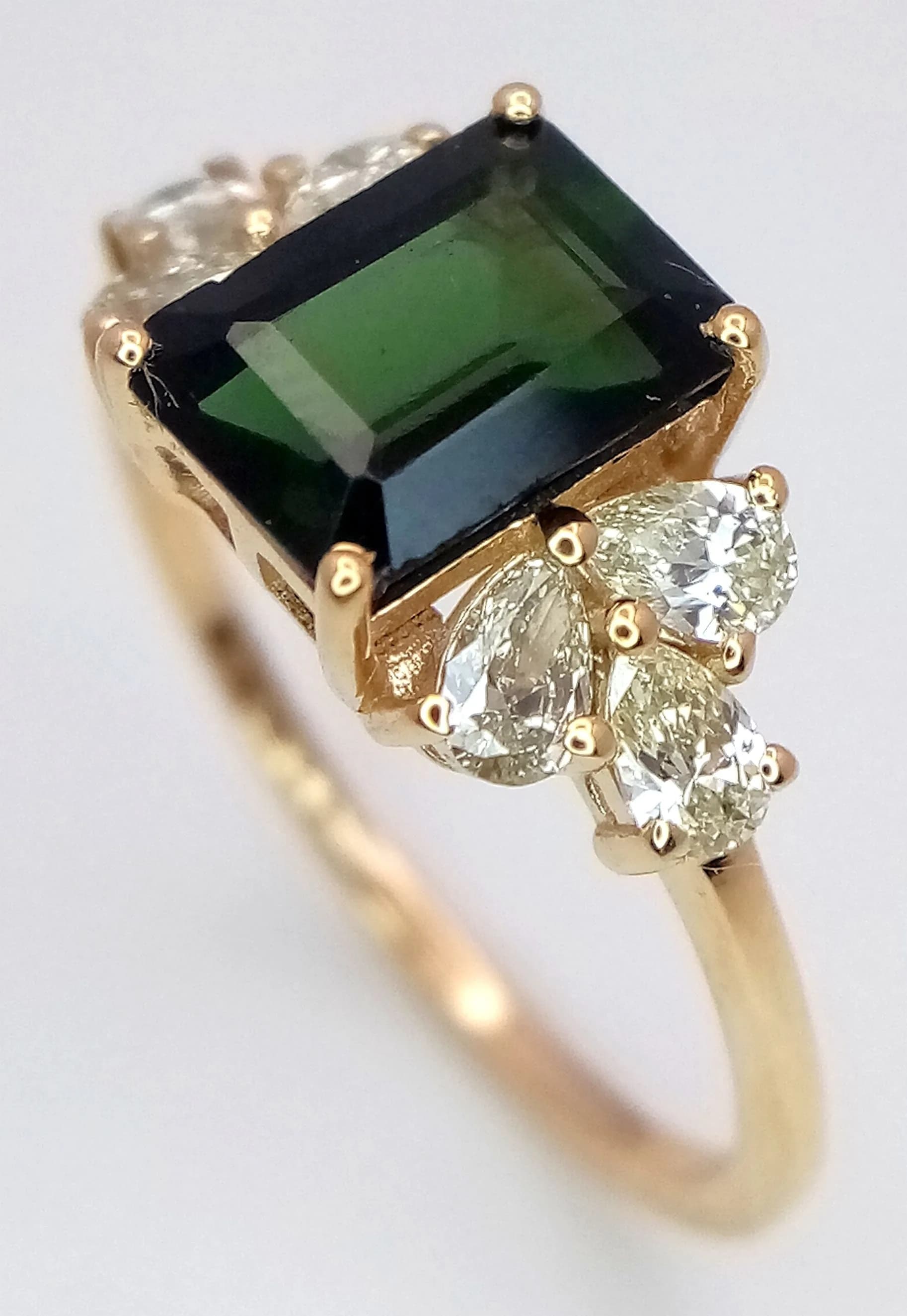 A 1.9cwt NATURAL GREEN TOURMALINE OCTAGON STEP CUT AND SET IN 14K GOLD AND FLANKED BY .48cwt OF DIAMONDS . 2.08gms size N COMING WITH THE H.R.D.ANTWERP CERTIFICATE