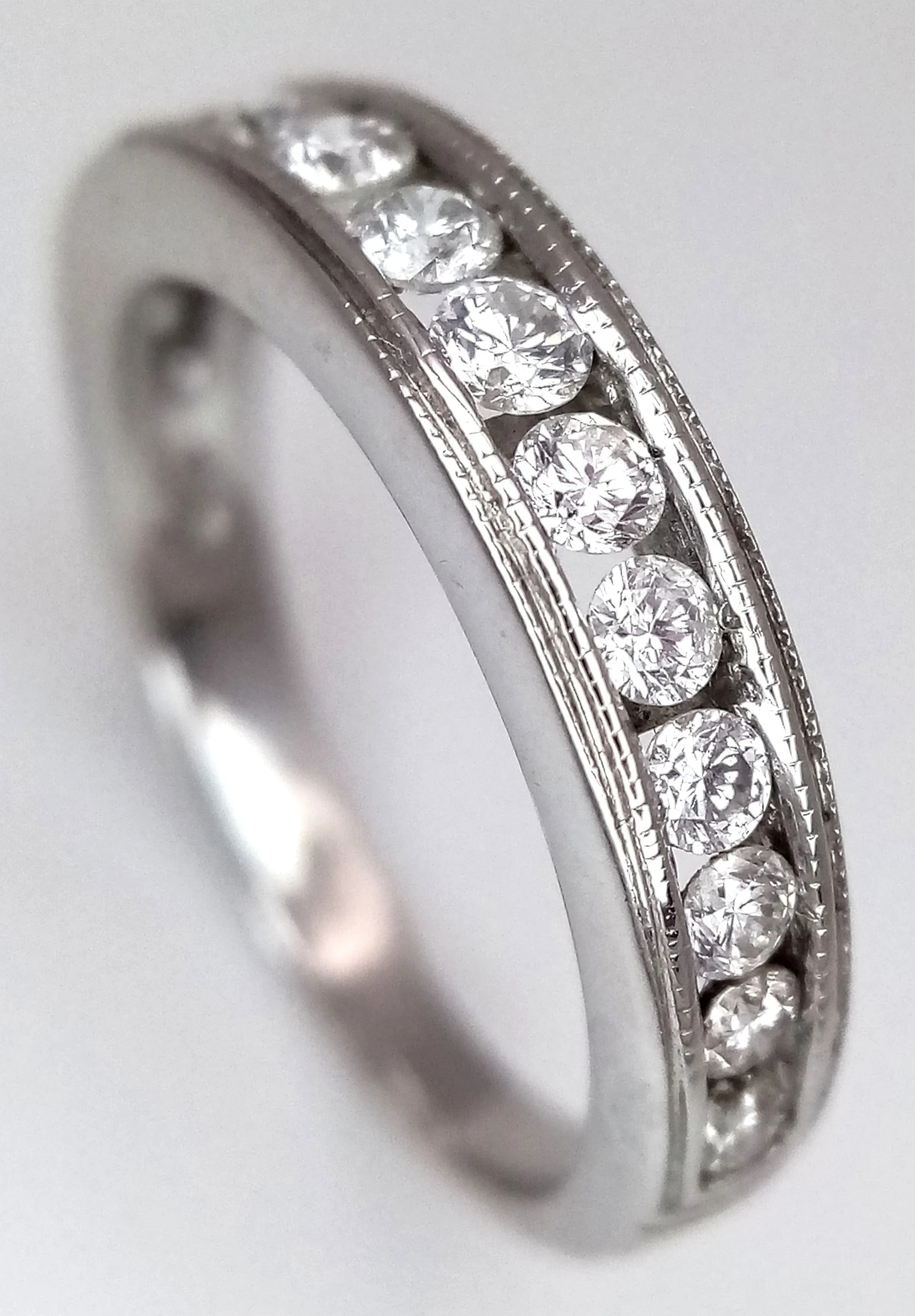 An 18K White Gold Channel Set Diamond Half Eternity Ring. 0.50ctw of 14 round brilliant cut diamonds having H colour and SI2 clarity. Size J. 3.3g total weight. MT08.