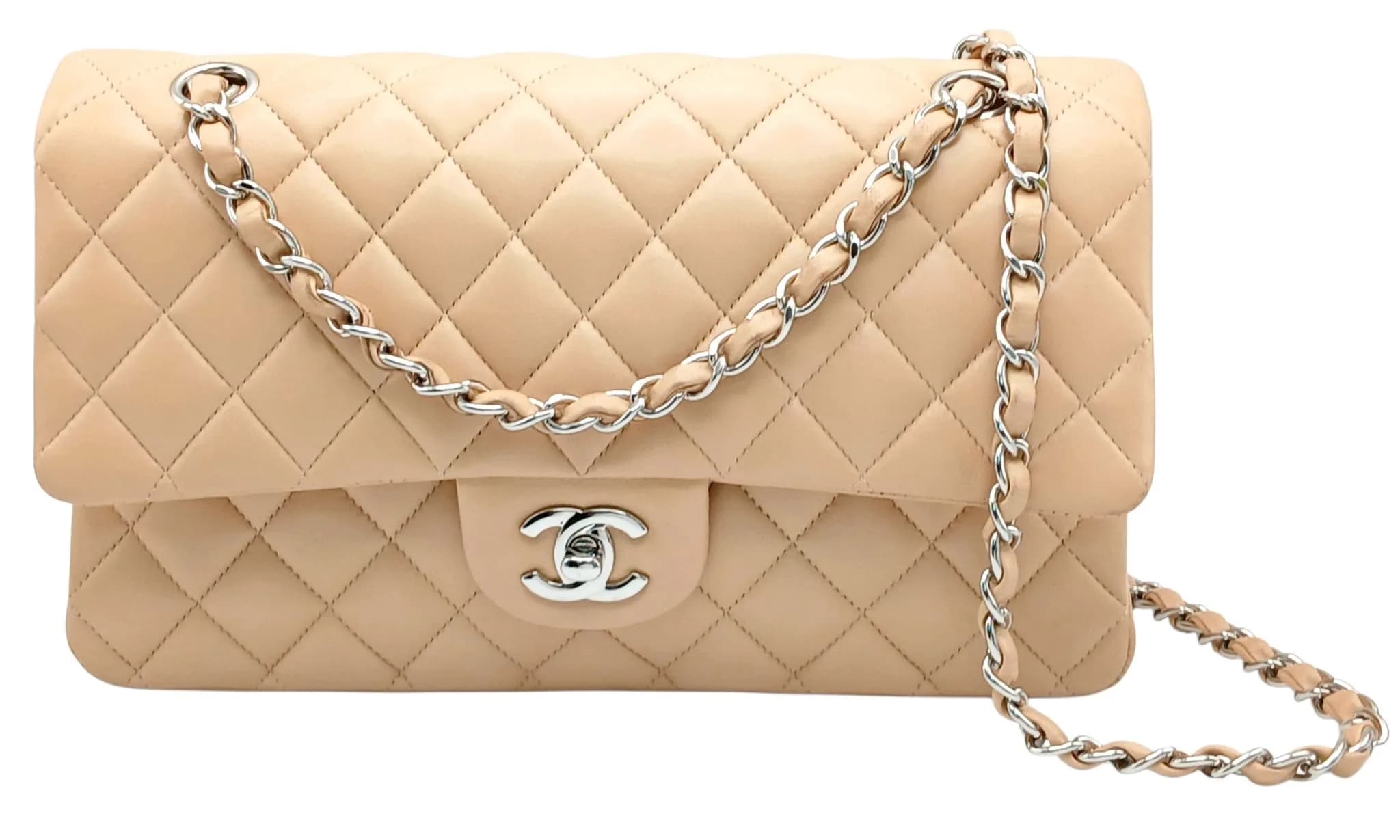A Beige Chanel Classic Double Flap Shoulder Bag. Beige quilted lambskin leather exterior with silver-tone hardware, signature CC turn-lock fastening and leather-interwoven chain shoulder strap. Beige leather interior with double flap construction, one main compartment and slip pockets. Approx. 25cm length x 15cm height x 6cm depth. Some marks, stains, scratches and signs of wear to the leather. Comes with a dust cover and certificate of authenticity. Please see photos or request a condition report. Ref: 29372.