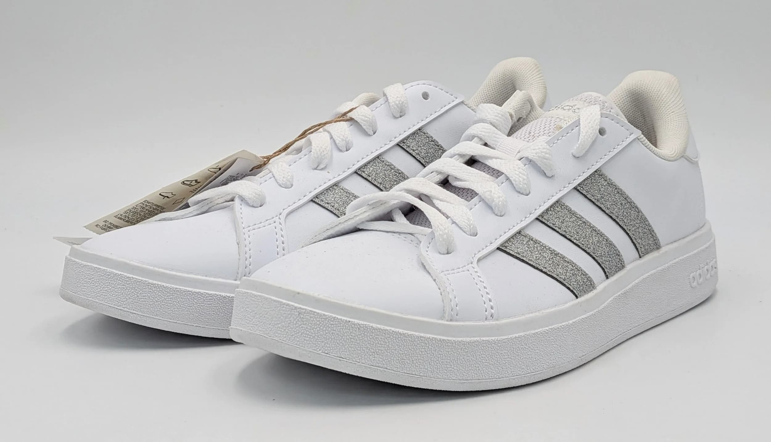 A pair of Adidas grand court trainers, white leather with silver glitter strips, New with tags and original box, Size UK 5, US 6.5