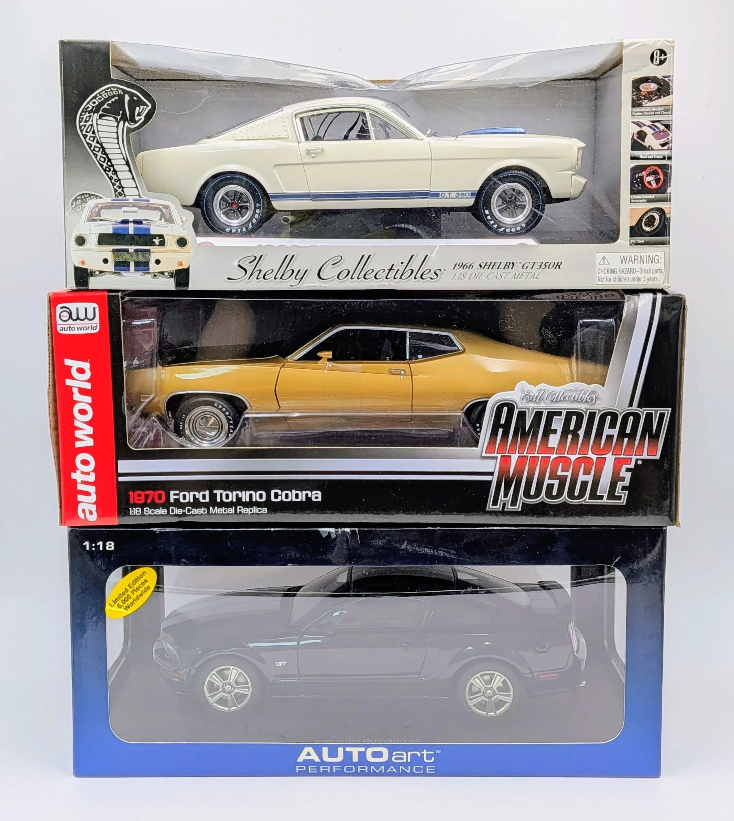 Three 1/18th scale die cast American muscle cars by Autoart, Ertl collectbles and Shelby collectibles. Two Mustangs & a Torino. Good condition. Slight wear to the boxes from storage.