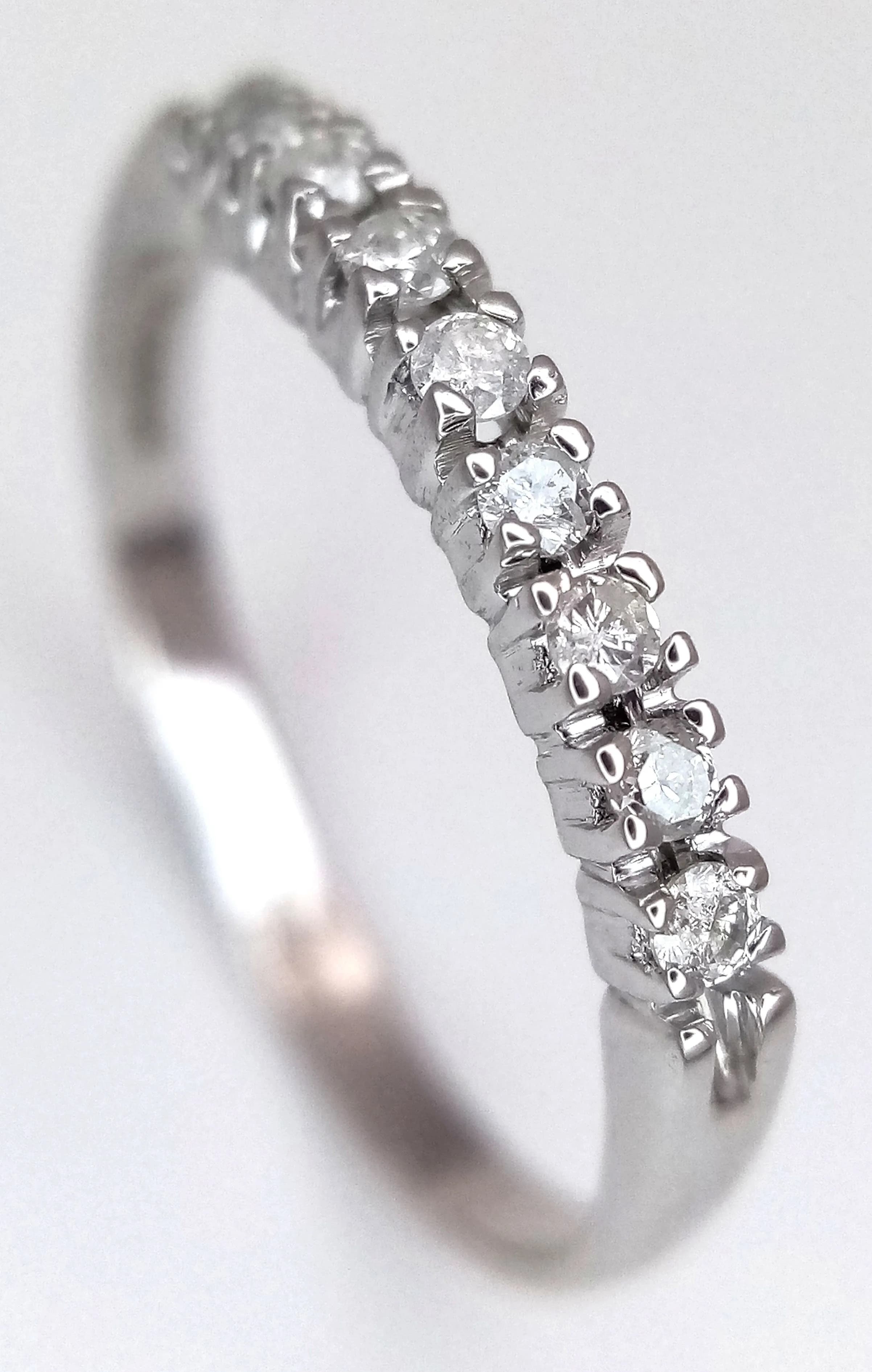 An 18K White Gold, Eight Stone Diamond Ring. 0.10ctw of round brilliant cut diamonds having H colour and SI1 clarity.Size L. 1.4g total weight. MT06.
