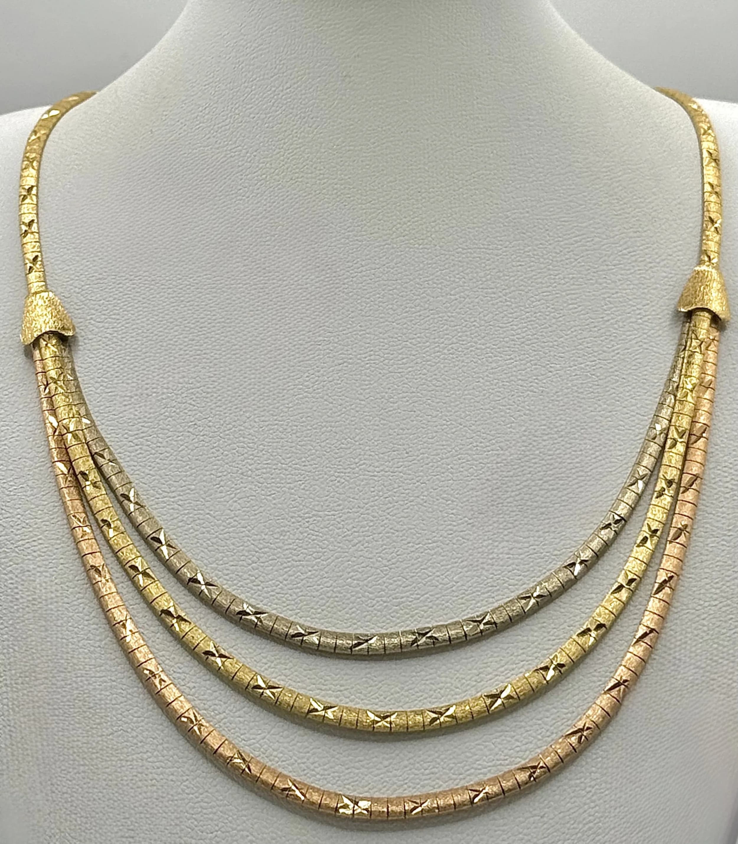 An 18K Tri-Coloured Gold Fancy Lavaliere Necklace. Graduating flat links of textured white, yellow and rose gold. 42cm. 31.55g.
