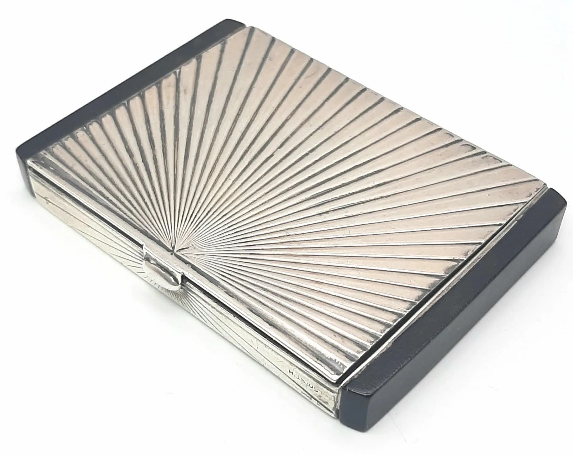 A GERMAN SILVER SNUFF BOX WITH ONYX SIDES AND SUNBURST DESIGN ON LID . 87.5gms 8.5 x 6cms