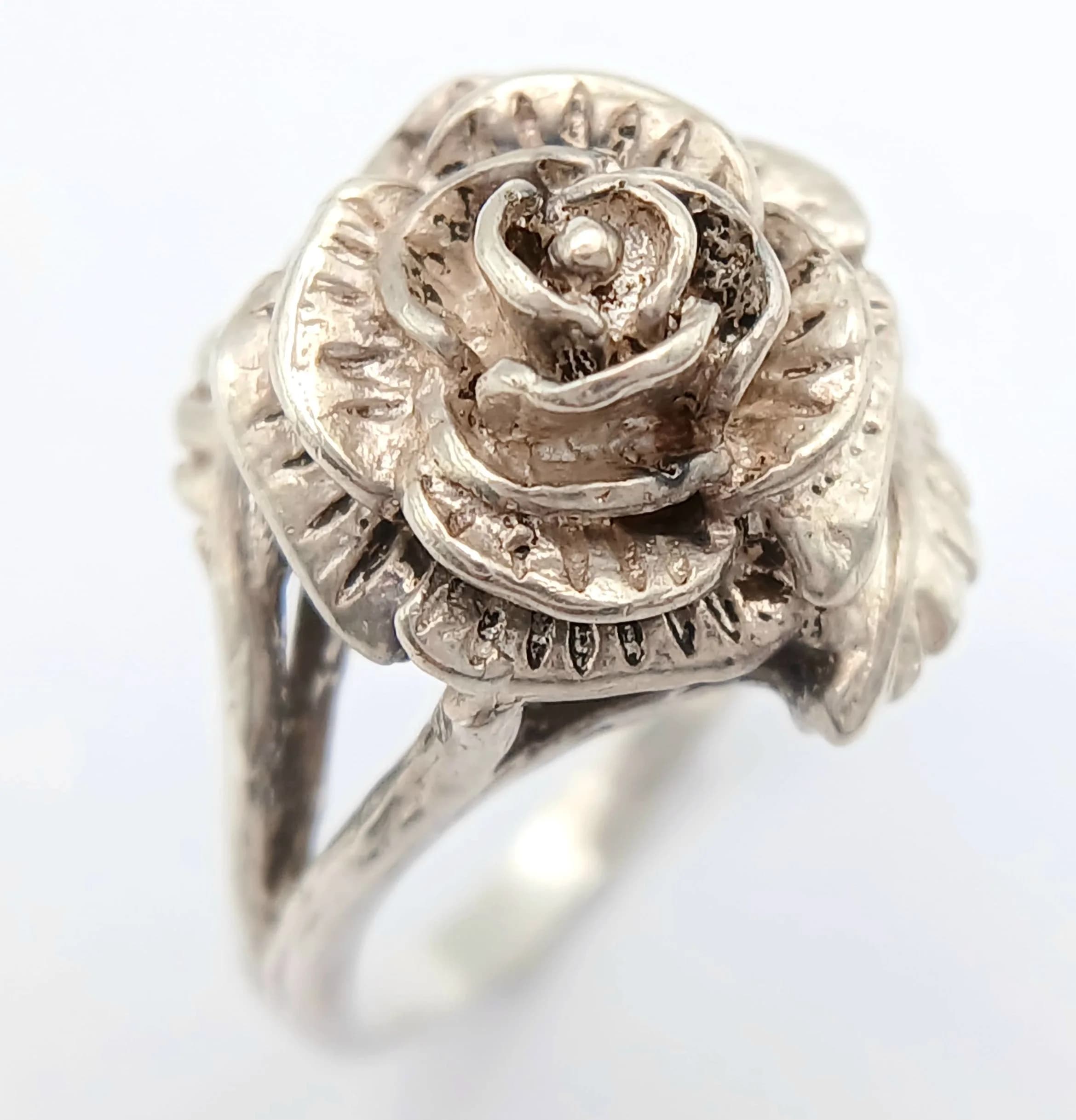 An Elegant Design Vintage, Hallmarked 1978, Sterling Silver Rose Design Ring Size N. The Ring measures 1.5cm diameter at the Crown and has a gross weight of 4.84 grams.