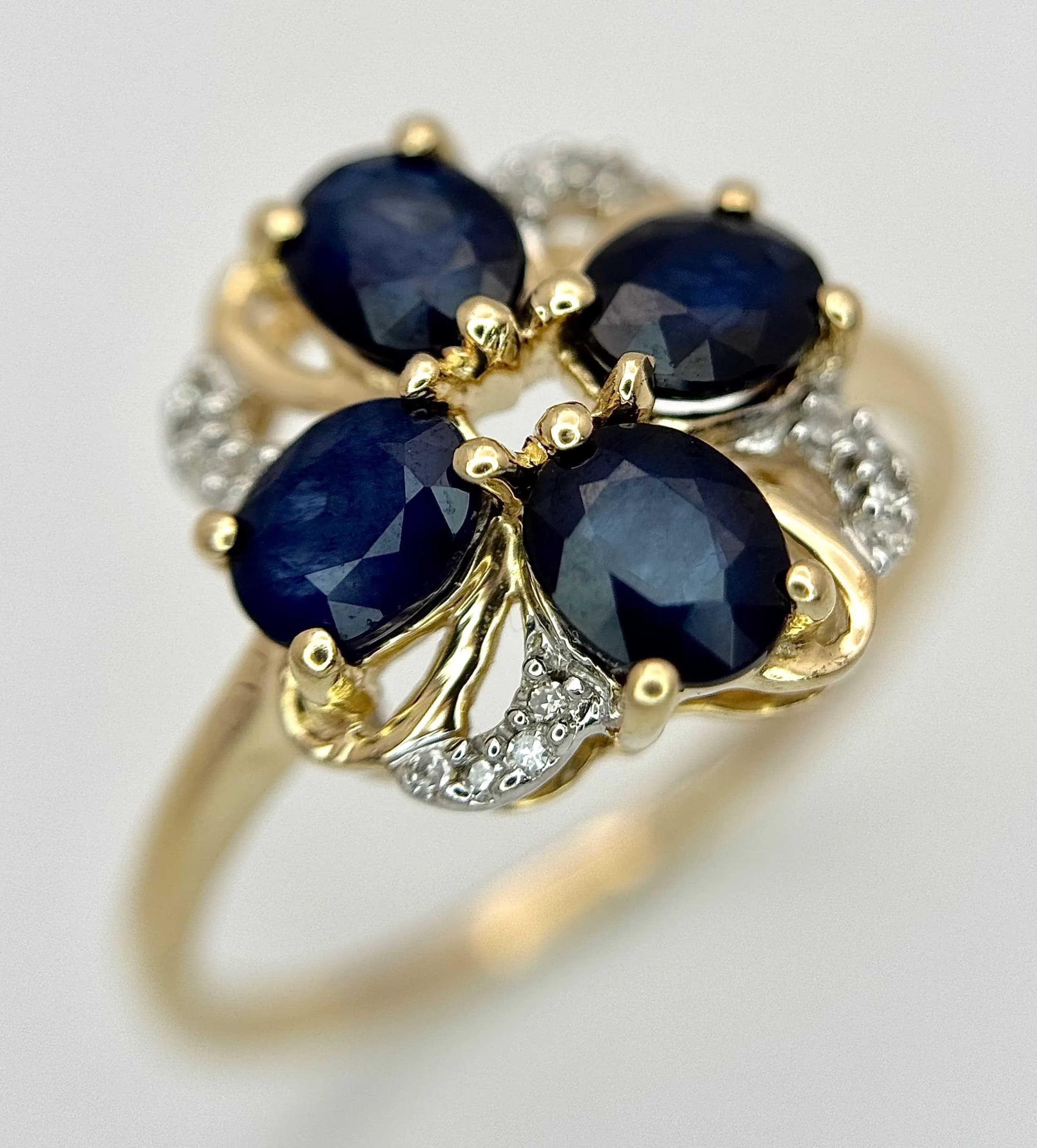 A Wonderful 10k Yellow Gold Blue Sapphire and Diamond Set Ring. Size P1/2. The Ring is set with four 5 x 4mm Oval Cut Blue Sapphires, approximately 0.5 carat each and Twelve Round cut Diamonds, approximately 0.06 carat total. The Ring has a gross weight of 2.63 grams. Appears practically unworn, if worn at all.