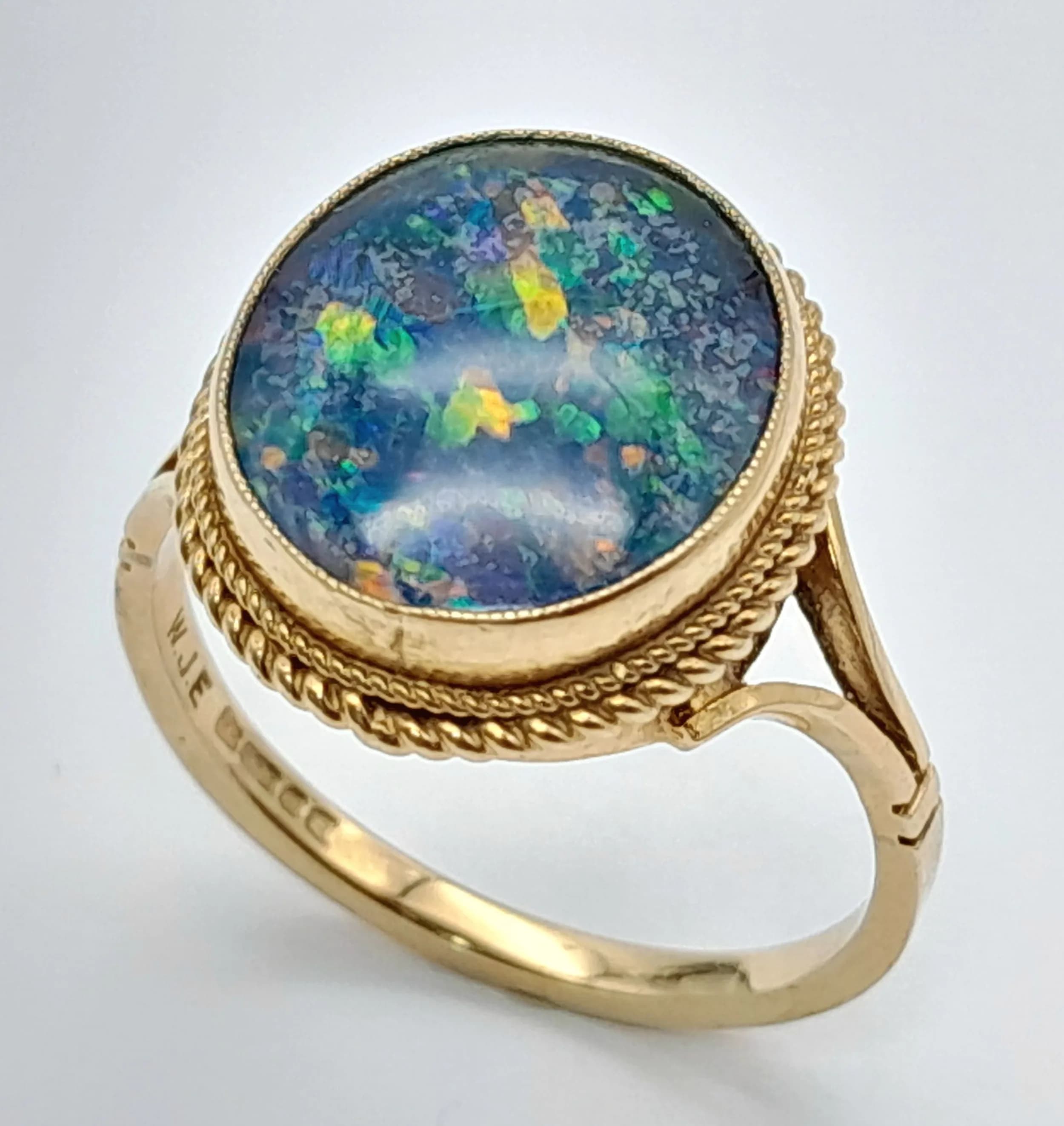 An Eye Catching 9k Yellow Gold Opal Triplet Ring. Size Q1/2. The Ring is set with a 13 x 11mm Oval Cut Opal Triplet that shows a beautiful array of colour. The Ring has a gross weight of 3.94 grams.