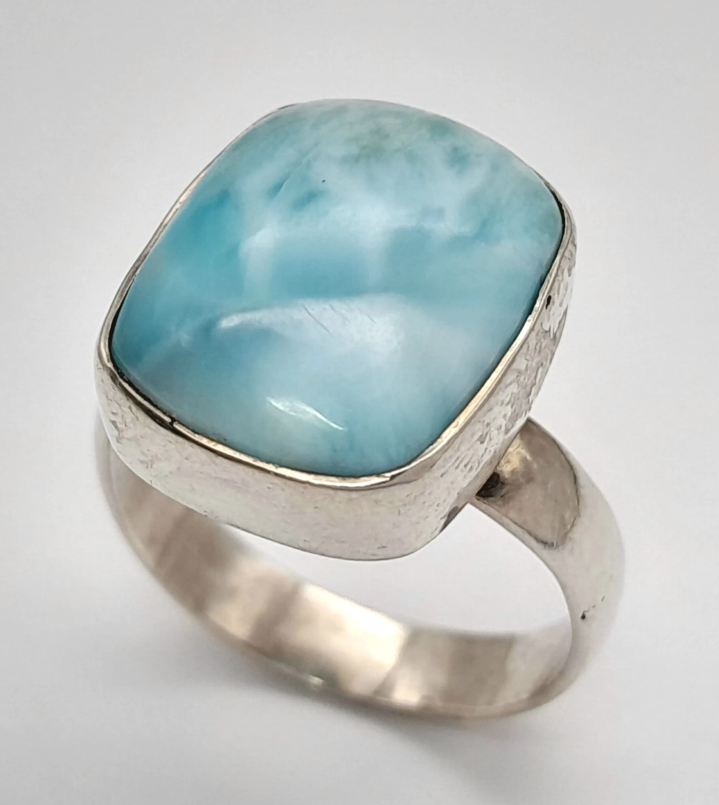 A Sterling Silver Unisex Blue Larimar Set Ring. Size U. The Ring is set with a 16 x 8mm Cushion Cut Larimar. The Ring has a gross weight of 6.91 grams.