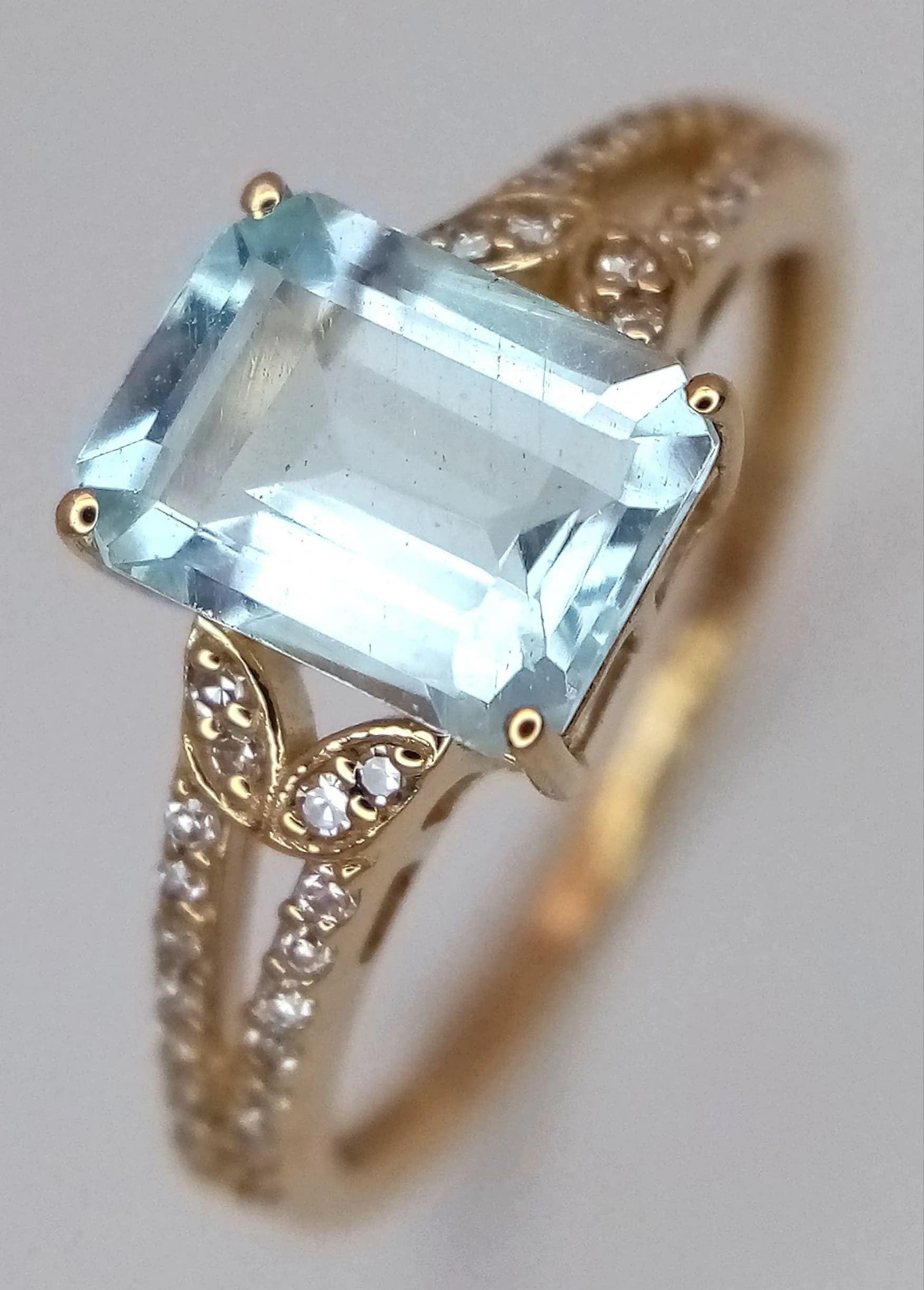 A 14K Gold, Aquamarine and Diamond Ring. A 1.43ct octagon step cut Mozambique aquamarine with a 0.12ctw diamond surround. Size N. 2.14g total weight. Comes with an HRD Antwerp certificate. Ref: CLR- 13731.