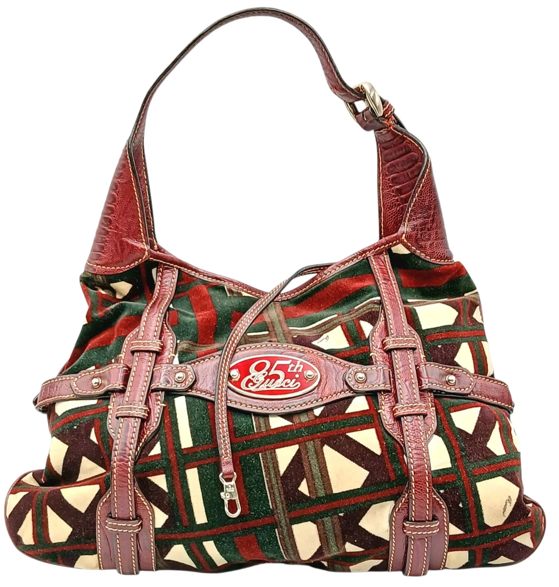 A Vintage Gucci 85th Anniversary Limited Edition Velvet Hobo Bag. Burgundy, green and cream geometric patterned velvet exterior with burgundy leather trim, silver-tone hardware and commemorative "85 Gucci" plaque to the front. Single leather shoulder strap with magnetic snap closure. Brown textile interior with one main compartment and a zipped side pocket. Approx. 37cm length x 28cm height. Comes with a dust cover. Please see photos or request a condition report. Ref: 29461.