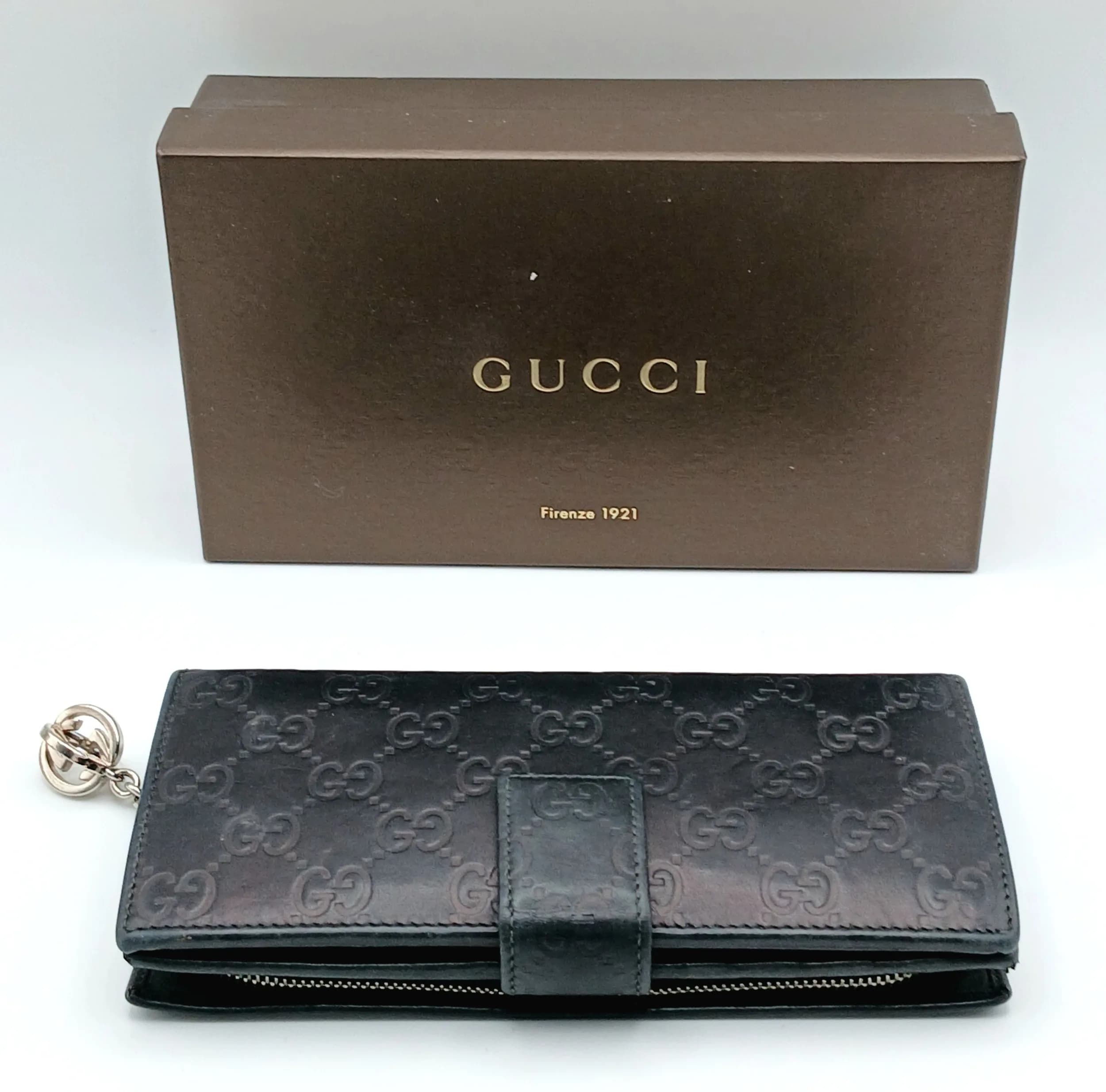 A Black Gucci Guccissima Continental Wallet. Black Guccissima embossed leather exterior with silver-toned, press-stud closure and GG logo zip pull. Black leather interior featuring multiple card slots, note compartments and a rear zipped coin compartment. Approx. 19cm length x 9cm height (when closed). Comes with a box and care booklet. Some scratches, marks and signs of wear to the leather. Please see photos or request a condition report. Ref: 29413.