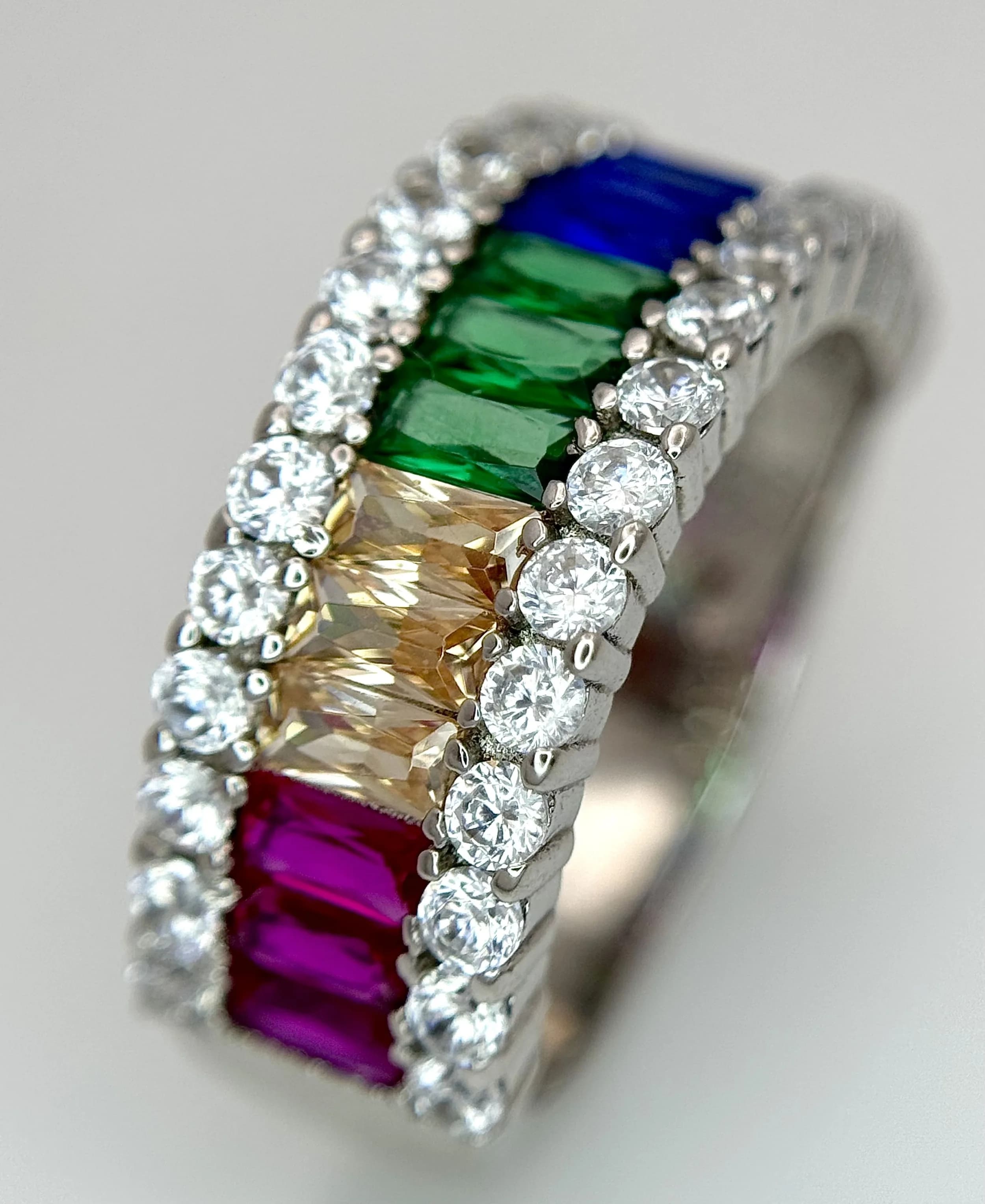 An ELANZA 925 Silver Simulated Rainbow Sapphire and Simulated Diamond Ring. Size N. 5.24g total weight.