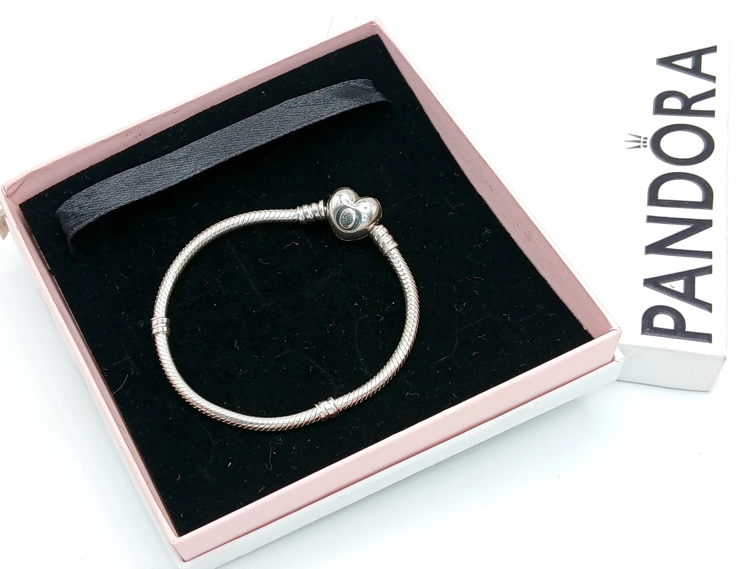 A Pretty Pandora 925 Silver Snake Chain Charm Bracelet. Fitted with Pandora's heart-shaped clasp and snake chain design. The bracelet measures approx 5.5cm internal diameter. Total weight 13.60 grams. Comes with Pandora presentation box.