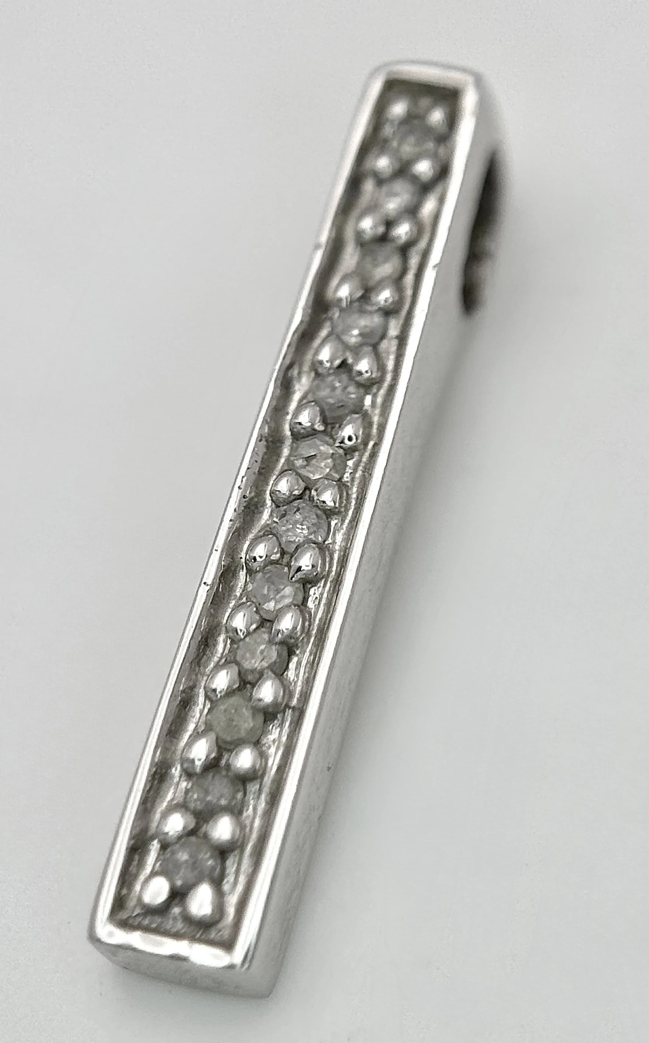 A 9K WHITE GOLD, DIAMOND SET, DROP PENDANT. 1.1G. TAN 6004