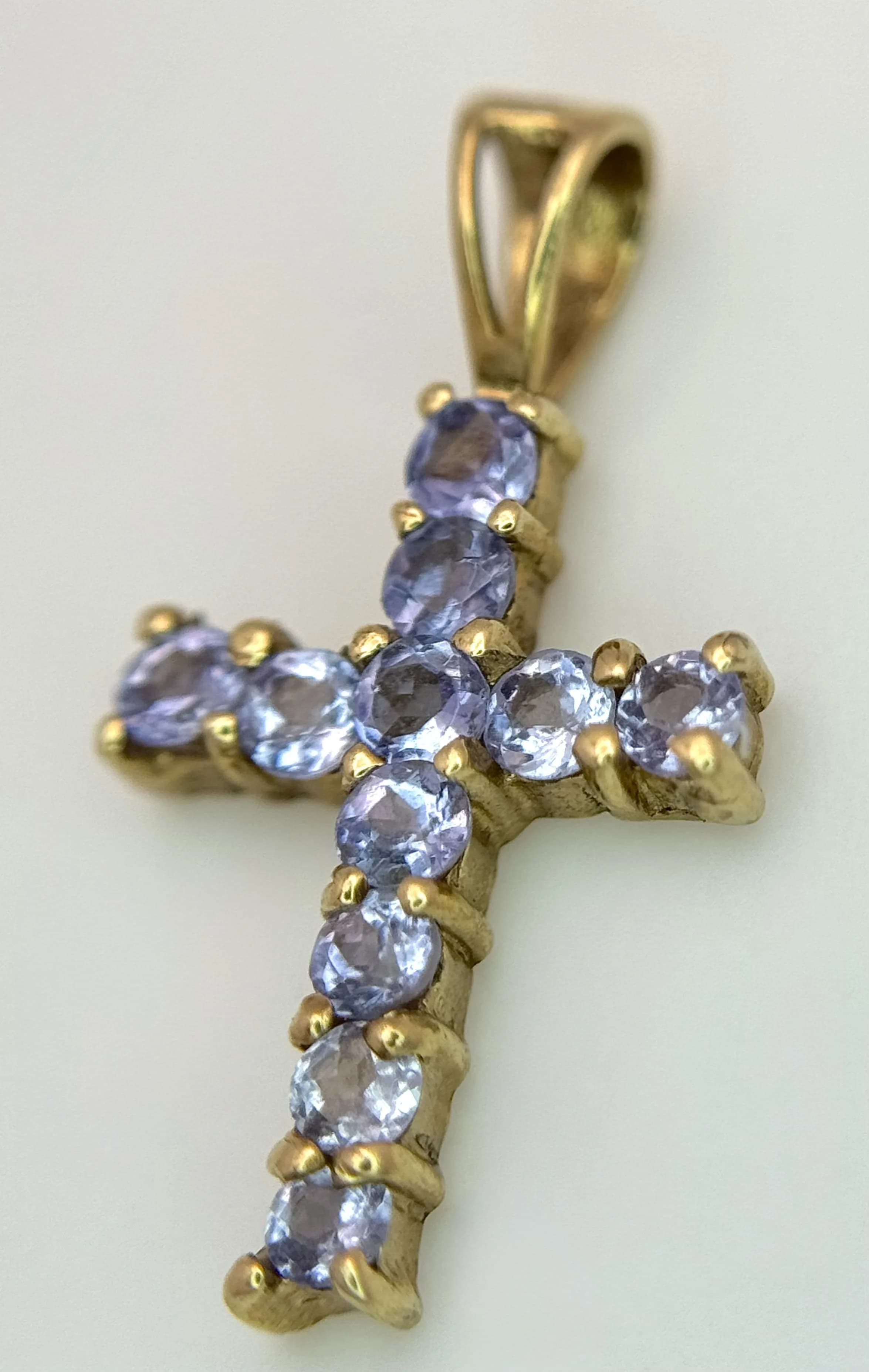 A 9K YELLOW GOLD, IOLITE SET CROSS PENDANT. 0.7G. TAN 6005