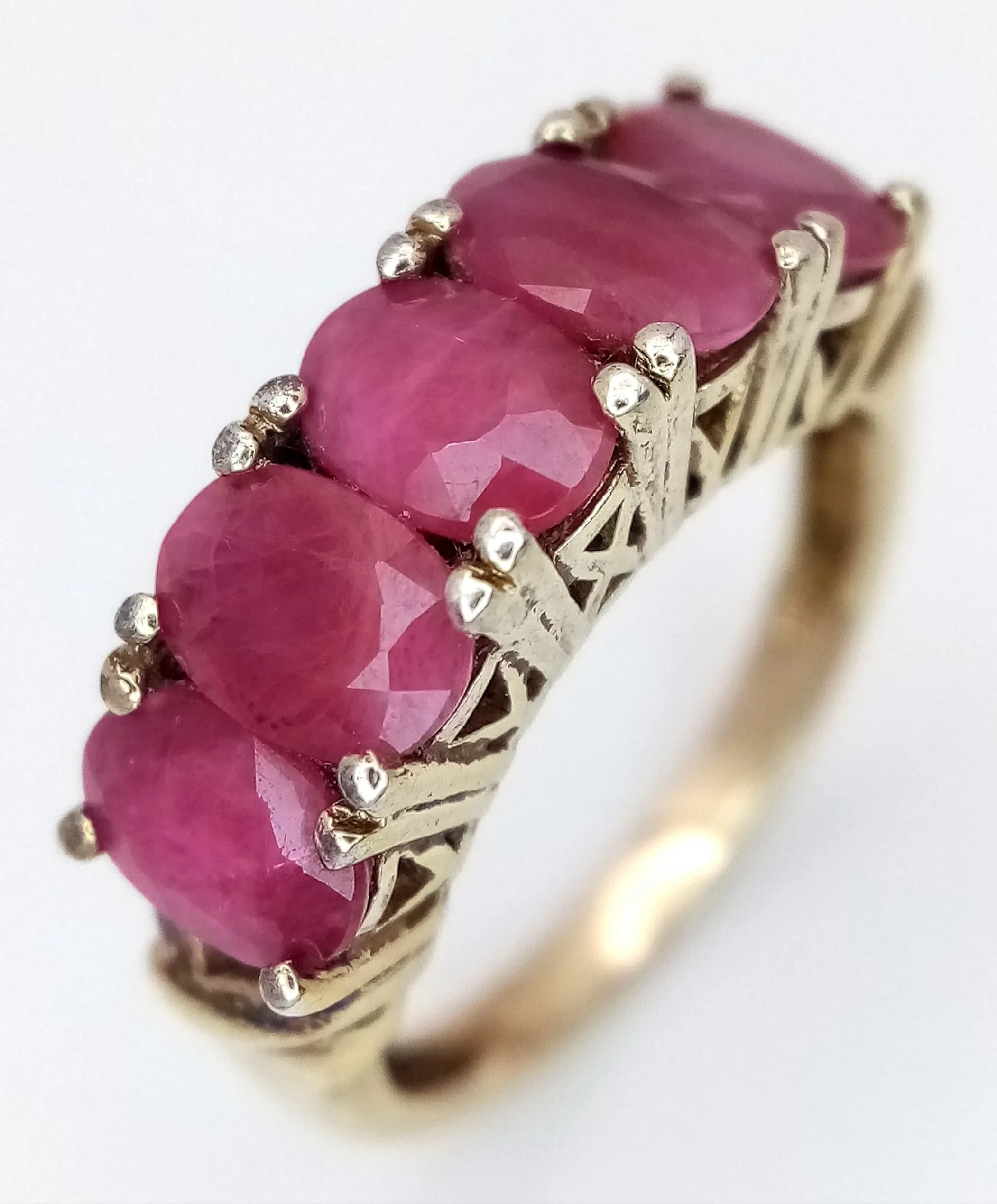 A Vintage Gold Gilded Five Ruby Set Ring Size K. The Ring is set with five 6 x 4mm Oval Cut Ruby’s each circa 0.40 carat. The Ring has a gross weight of 3.18 grams.