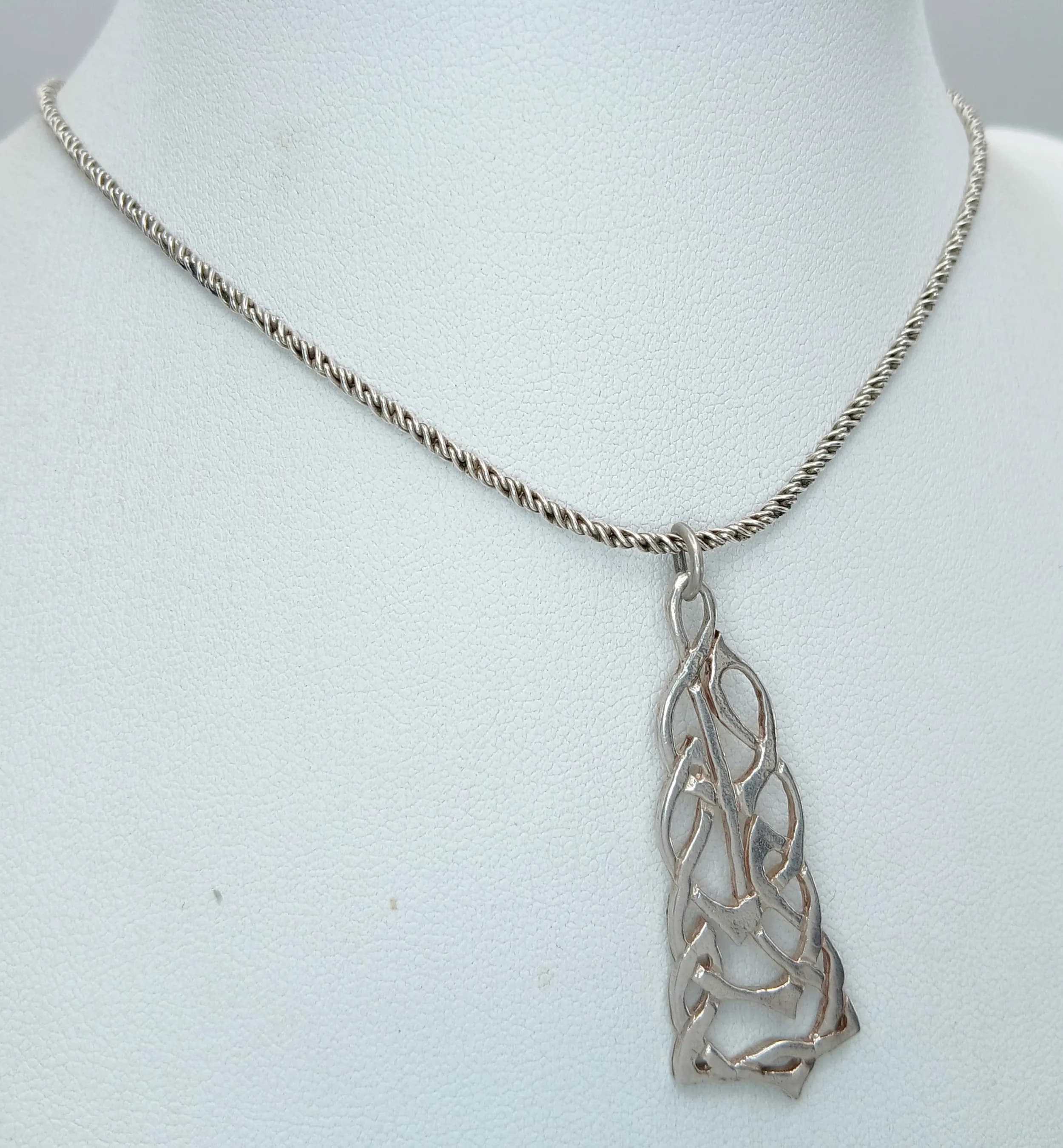 A Lovely 925 Sterling Silver Celtic Knot Pendant Necklace - 39cm Length. Features an openwork Celtic knot drop pendant on a fine twisted silver chain. The pendant measures 4cm x 1.5cm. Gross weight 8.81 grams.