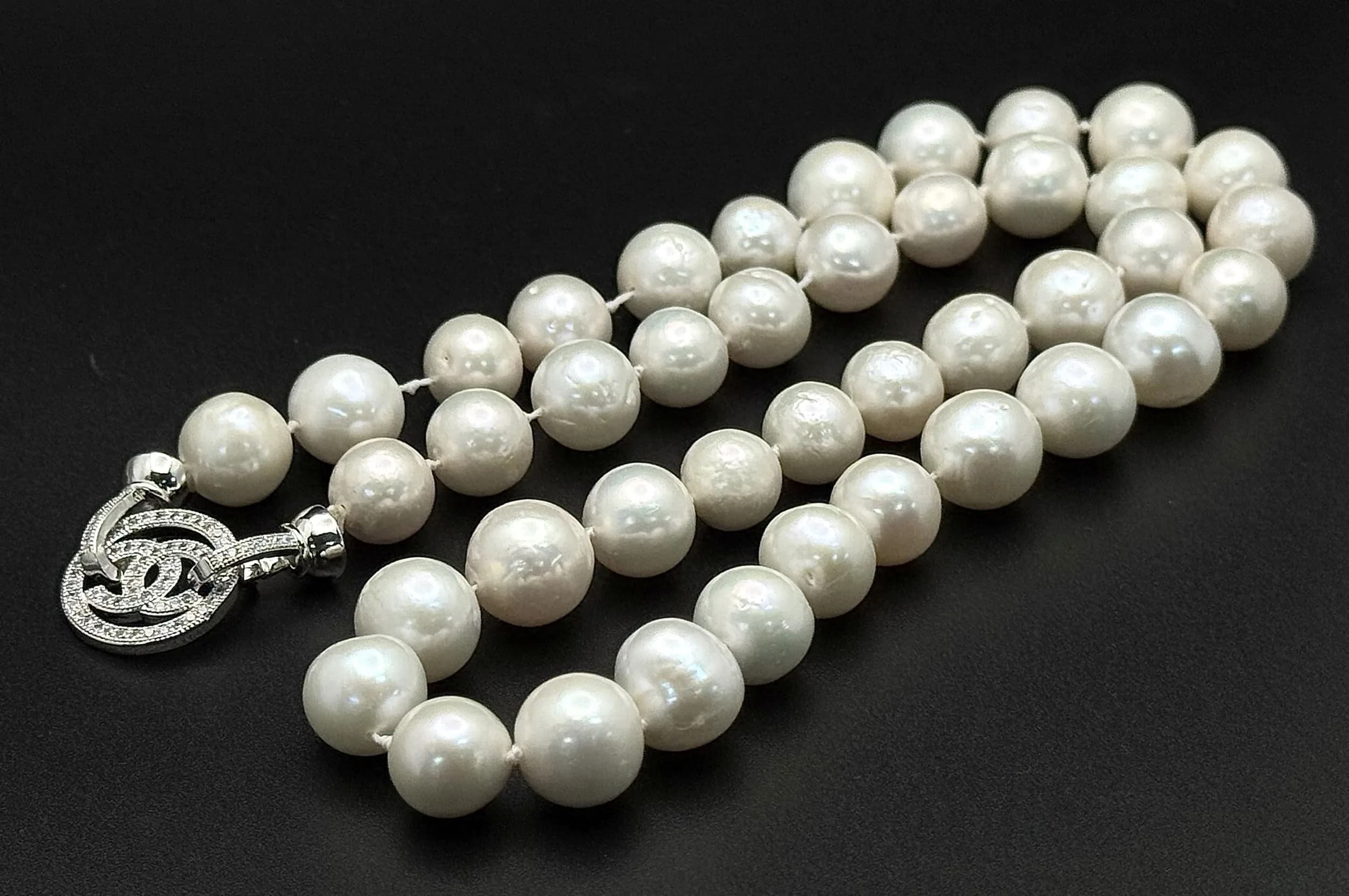 An Elegance White Freshwater Pearl Necklace – 46cm Length. Features a single strand of white freshwater pearls with a silver-tone CC logo clasp. 10.5mm Pearls.
