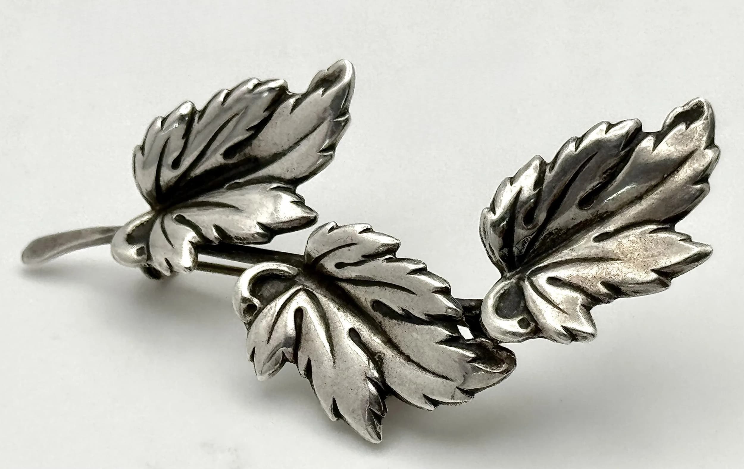 A Vintage 925 Silver Leaf Brooch. Features three finely detailed cascading leaves with textured veining and a secure pin fastening. The brooch measures 6.5cm x 2.5cm. Total weight 5.41 grams.