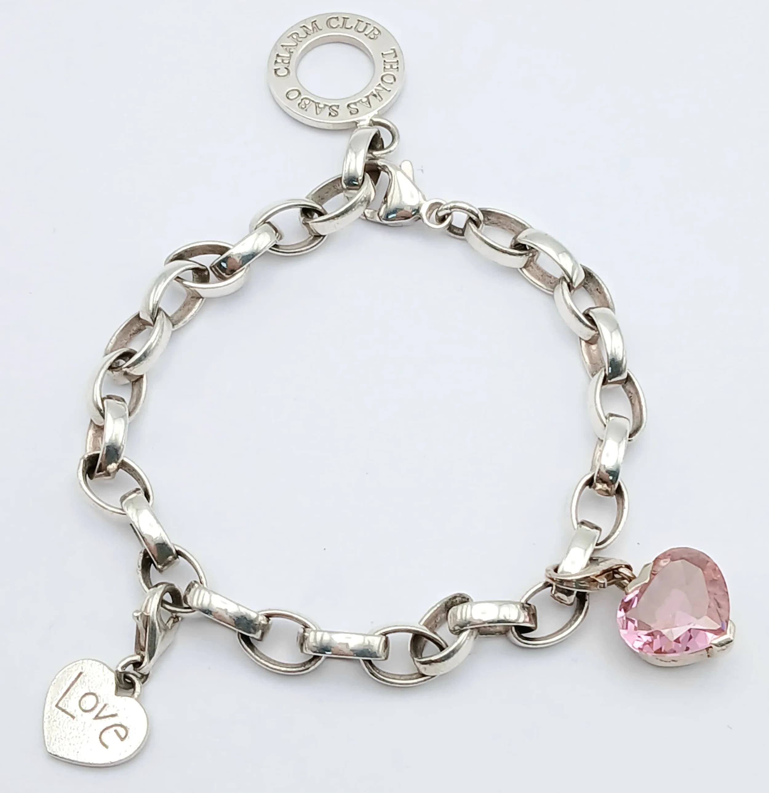 A THOMAS SABO, STERLING SILVER CHARM BRACELET, WITH 2 X THOMAS SABO SILVER CHARMS. STONE SET HEART AND HEART ENGRAVED WITH THE WORD LOVE. 19.3G. TREV SIL 6001