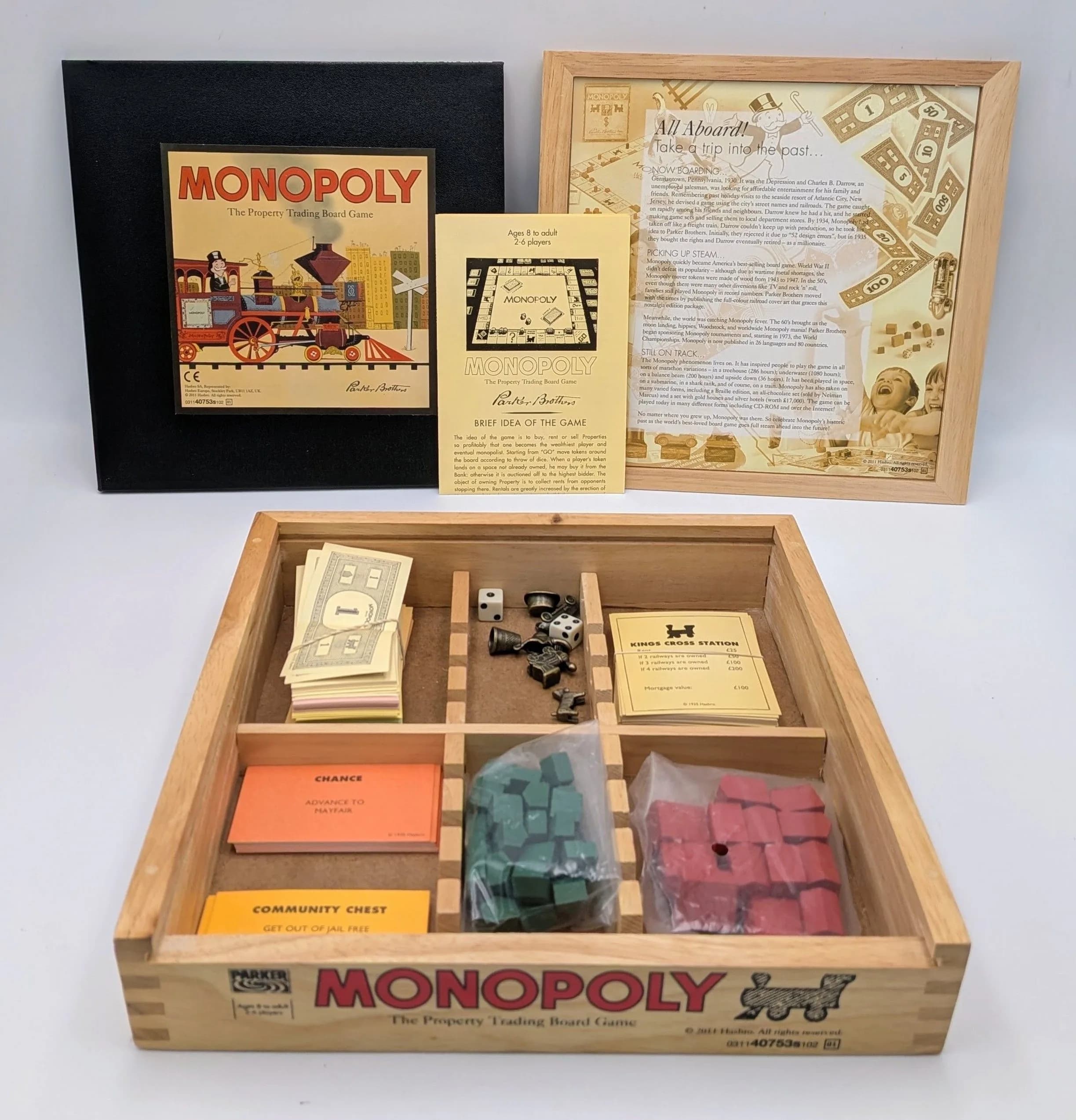 A Compact Monopoly Board Game. Comes in a wood case. 26 x 26cm. Please see photos for finer details.