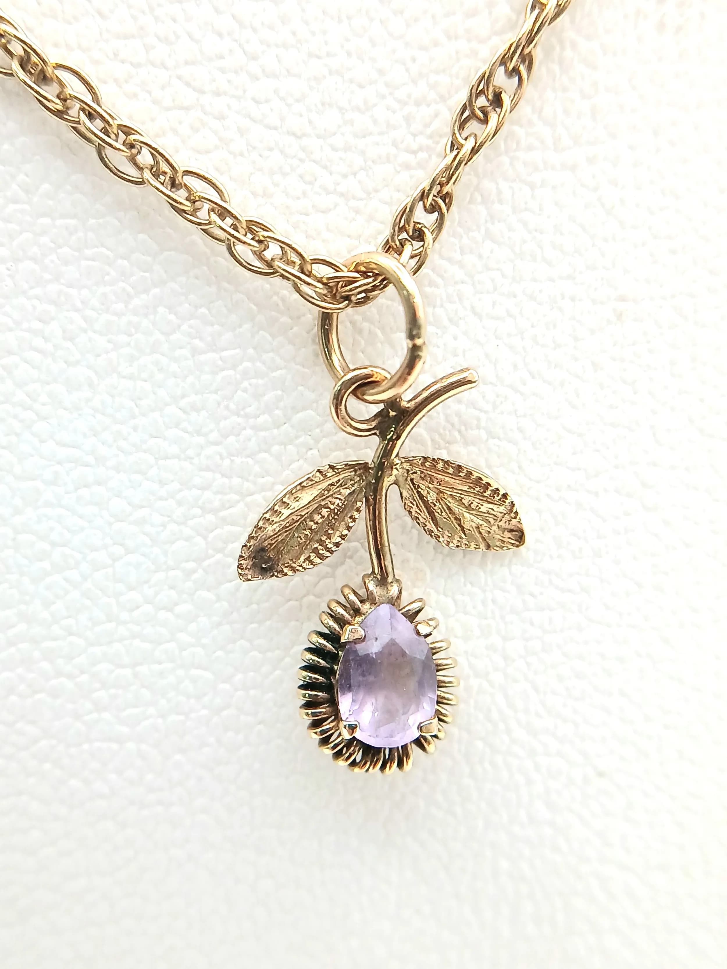 A 9K Yellow Gold Amethyst Pendant in Floral Form on a 9K Gold Chain Necklace. 2cm and 46cm. 3g total weight.