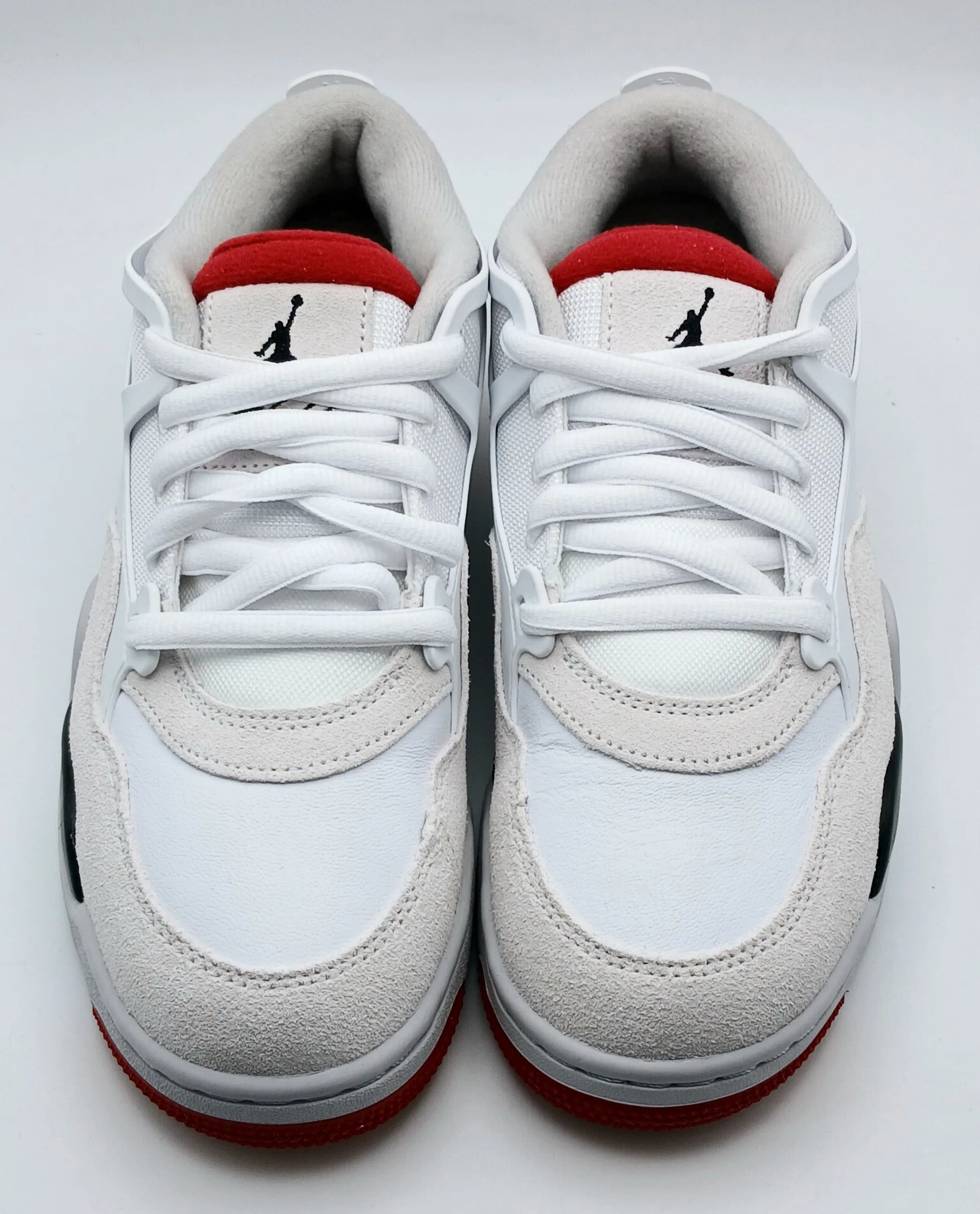 A pair of Nike Air Jordan 4 RM trainer, white leather with black and red accents. New, no box. UK size 6, US size 6.5Y