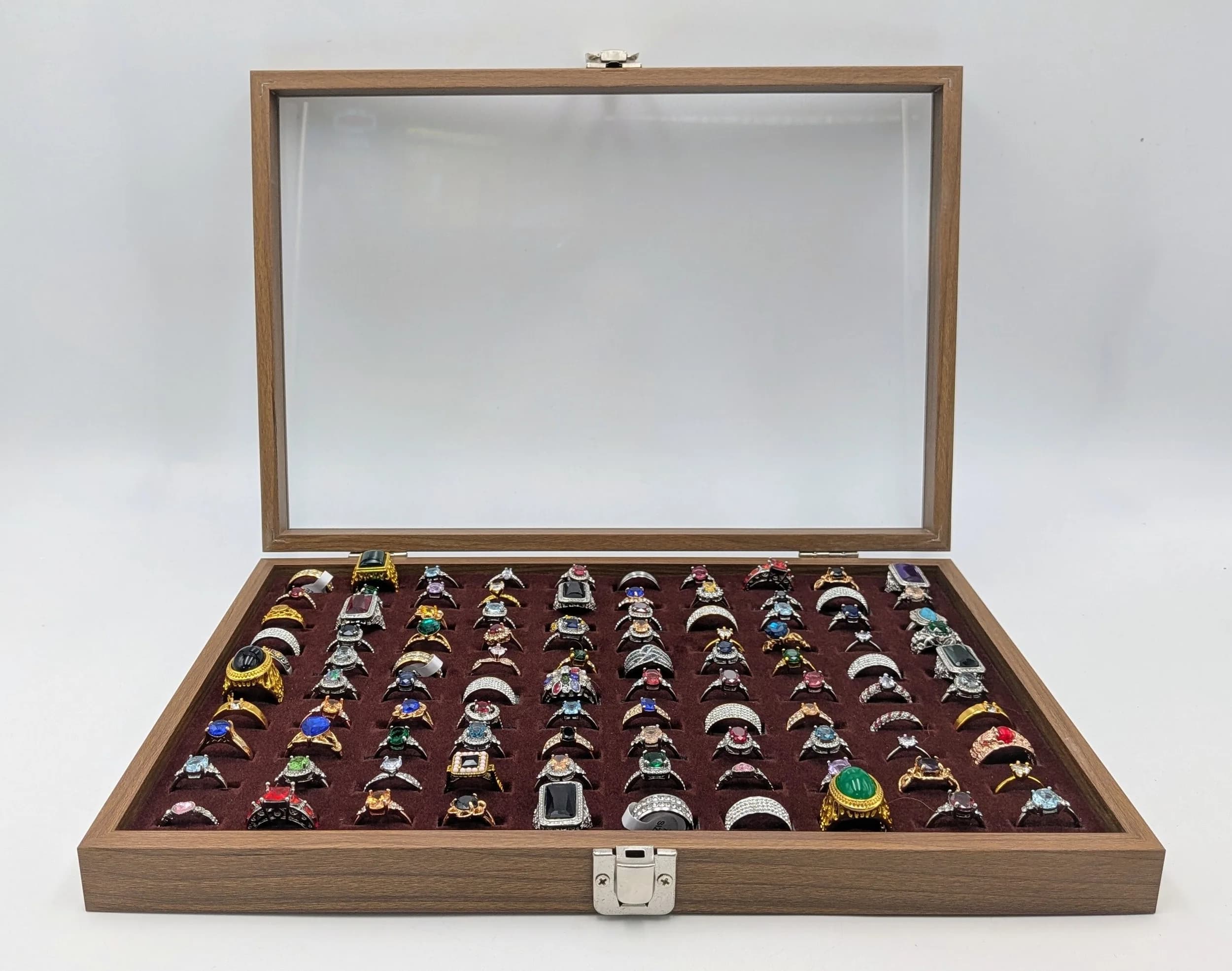 A Jewellery Display Case with 100 Rings! An absolutely fabulous lot with different colored stones to acrylic/resin decoration. All types of stone cuts with gilded and white metal shanks of different design. Sizes range from small to large. All rings in excellent condition. Case size - 35 x 24cm.