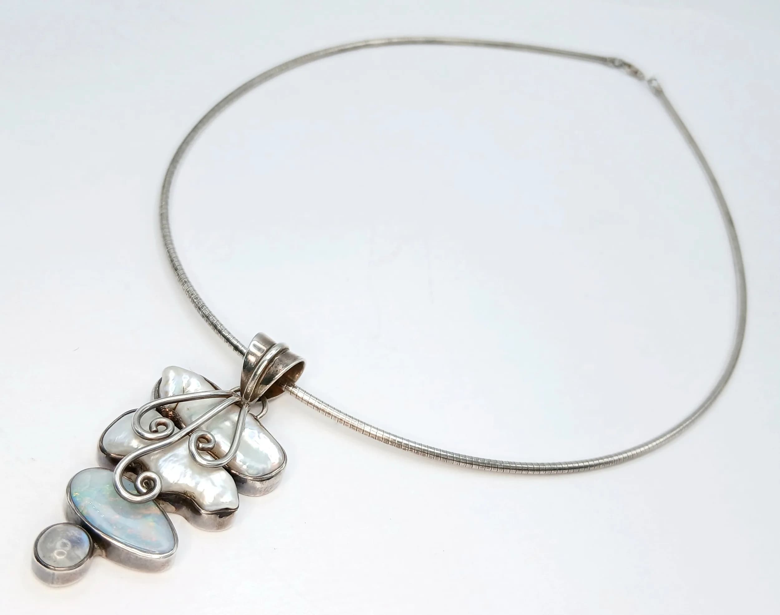 A 925 Silver Mother of Pearl and Moonstone Pendant Necklace. 5cm length pendant, 46.5cm length omega snake chain. 23.48g total weight.