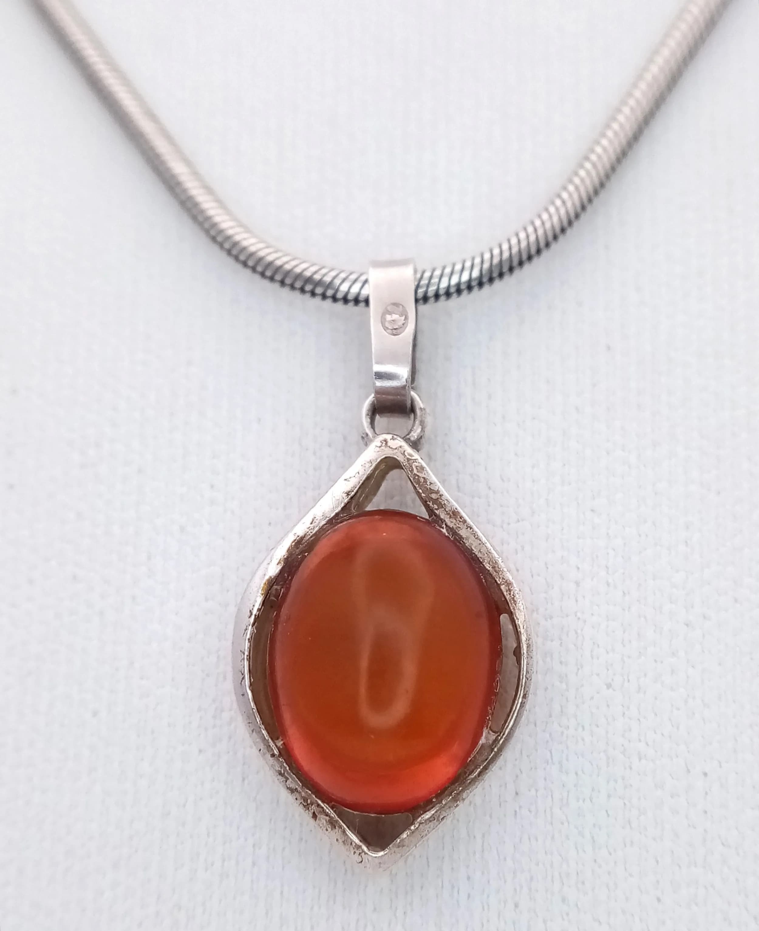 A Stylish Italy 925 Silver Amber Cabochon Pendant Necklace - 44cm Length. Features a polished oval amber cabochon in an elegant open teardrop-style silver setting on a fine snake chain. The pendant measures 2cm x 1.2cm. Gross weight 11.28 grams.