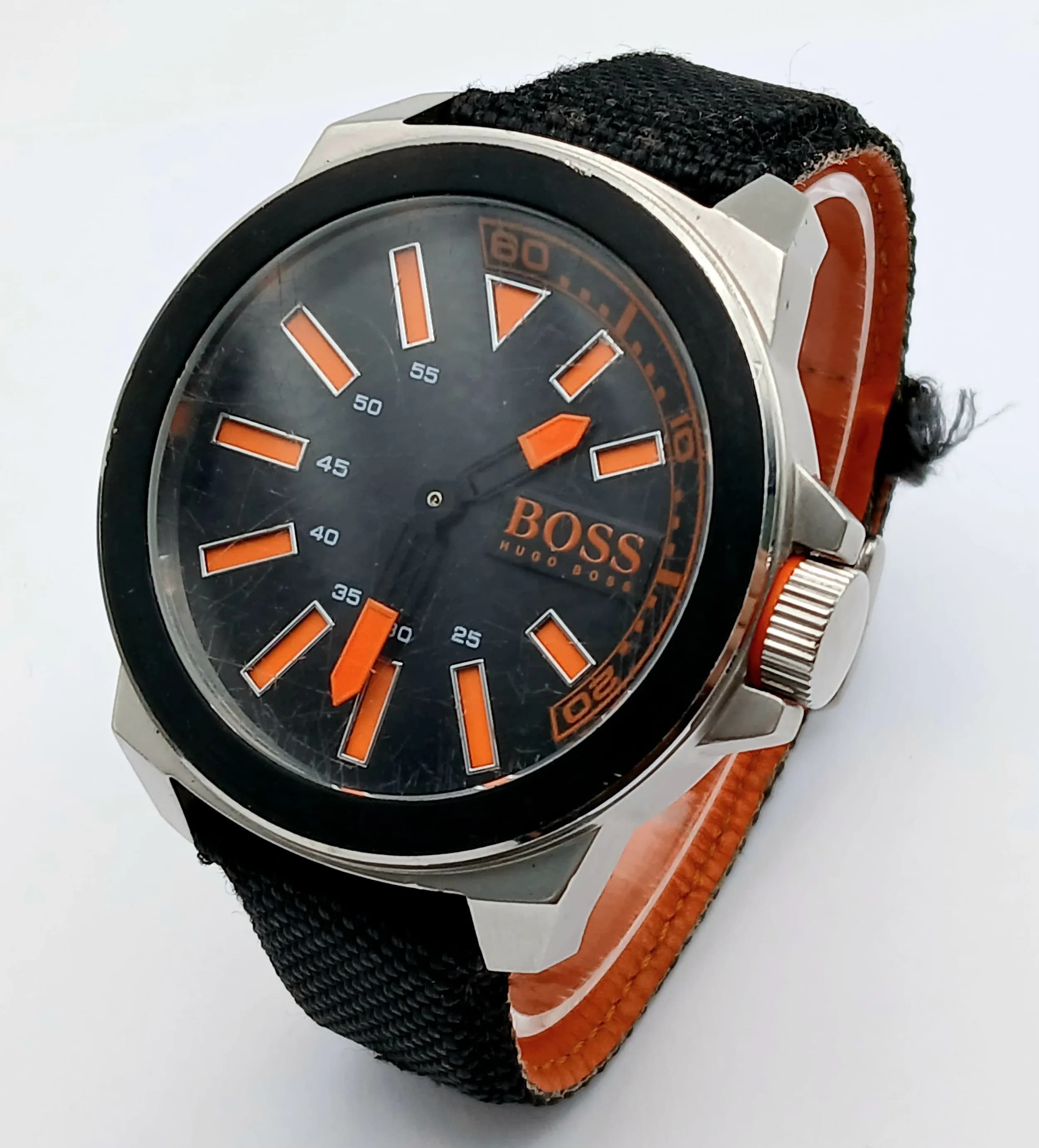 A HUGO BOSS, BLACK MATERIAL STRAP WATCH. ORIGINAL STRAP AND BUCKLE WITH ORANGE ACCENTS. IN FULL WORKING ORDER, NEW BATTERY FITTED RECENTLY. S/A 1323 - 1