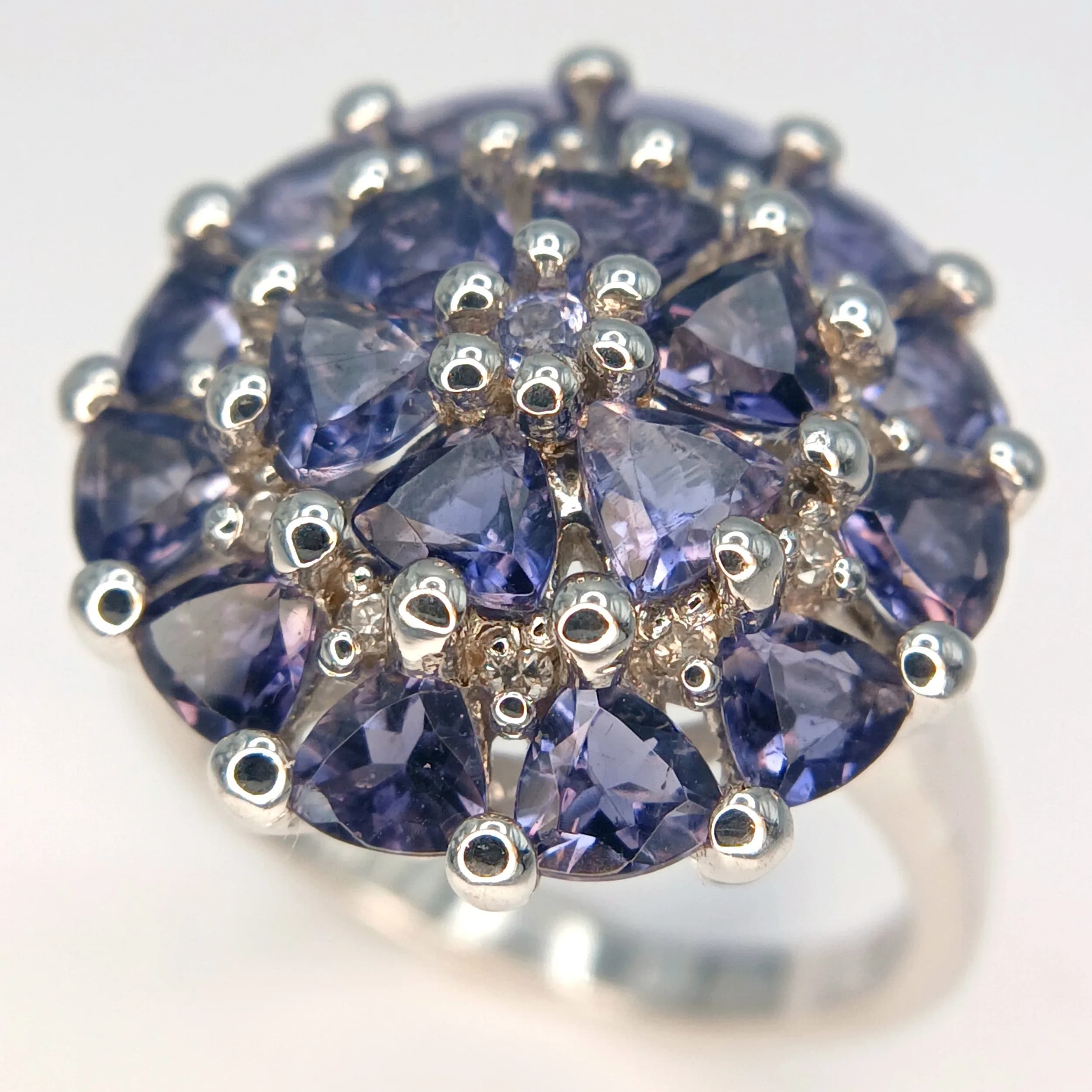 A Beautiful Sterling Silver Tanzanite and White Zircon Cluster Ring. Size R. The Ring measures 2cm Diameter at the Crown which is tier mounted with Trillion Cut Tanzanite and Round Cut White Zircon. Gross weight 6.79 grams.