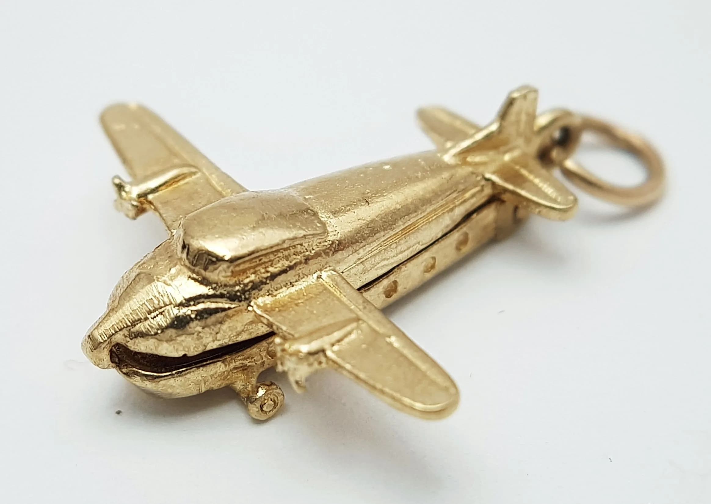 A 9K YELLOW GOLD, CARGO PLANE, CHARM / PENDANT. PLANE OPENS TO REVEAL 2 CARS INSIDE. 3.3G. SC 5012