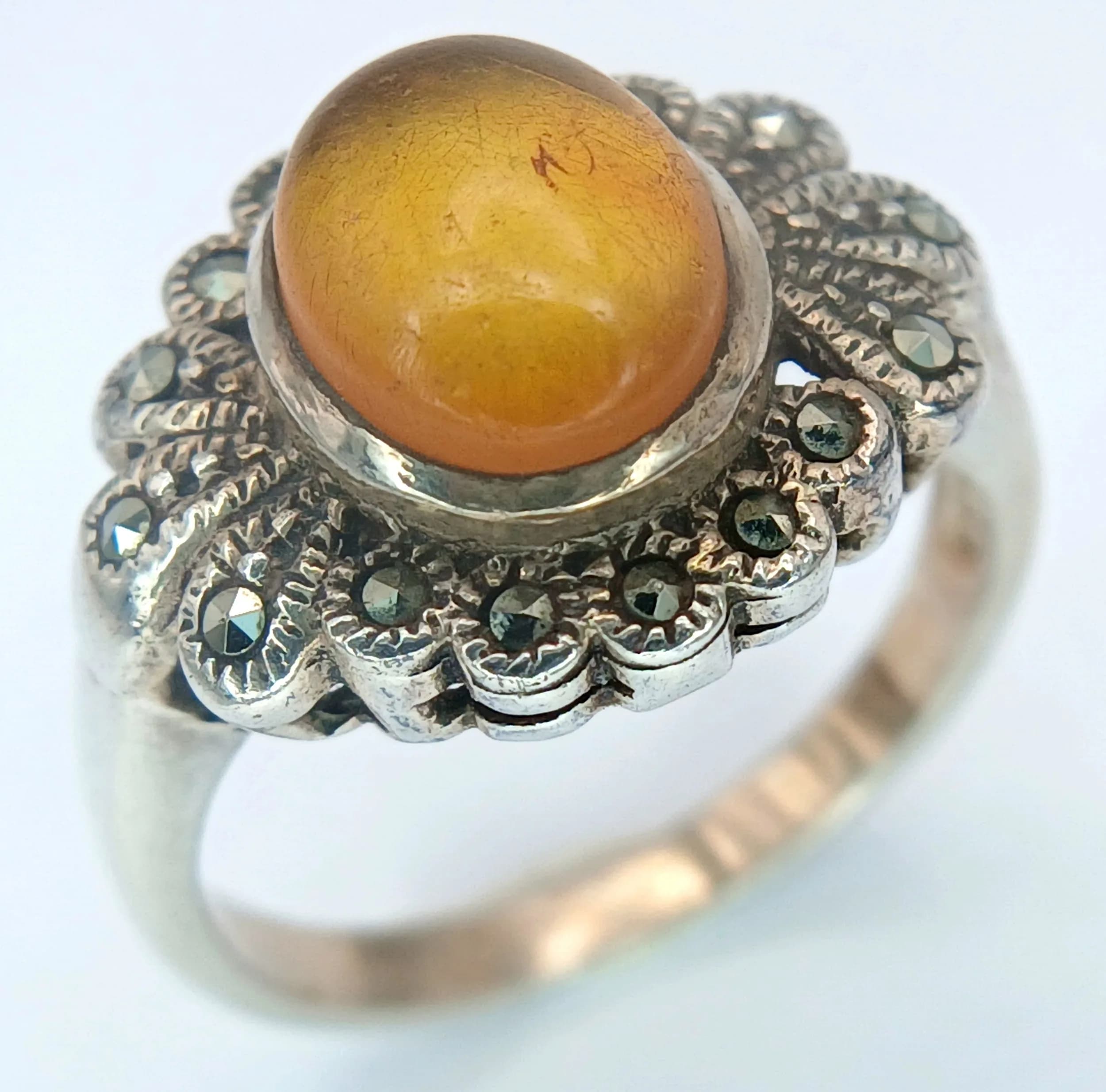 A Vintage or Older Art Deco/Victorian Revival Sterling Silver Yellow Stone (likely Amber) and Marcasite Ring Size P. The Crown measures 1.6cm Length and the Ring has a gross weight of 4.68 grams.