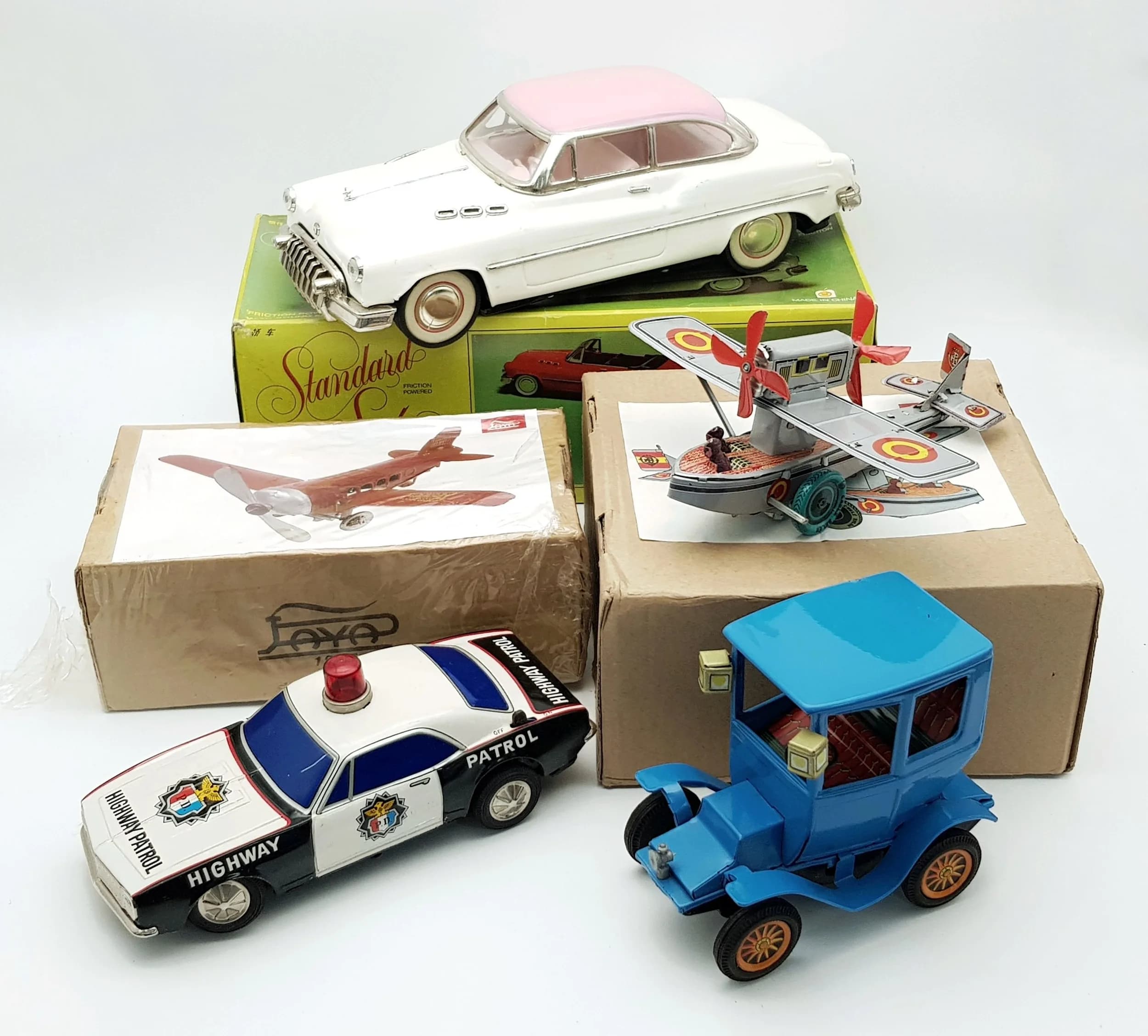 Three boxed tin plate toys. Including a vintage Voiture Standard Sedan. In very good condition. Comes with two loose tin plate toys.