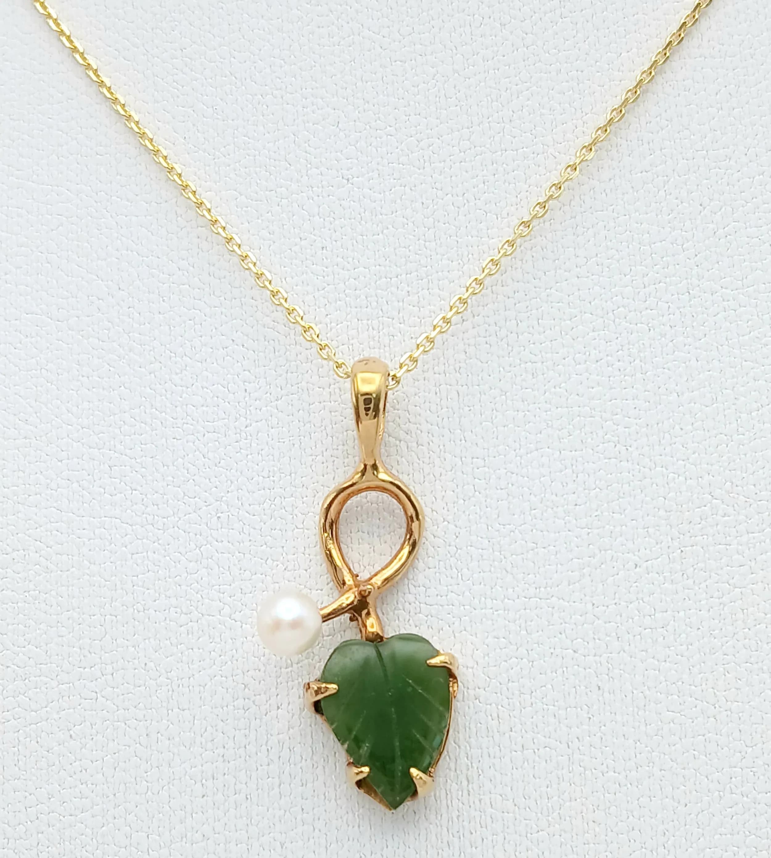 A Gold Gilded Nephrite Jade and Pearl Leaf Design Pendant Necklace- 46cm Length Gold Gilded Sterling Silver Chain. The Pendant measures a 2.6cm drop and is 1.2cm Wide. The Necklace has a gross weight of 2.9 grams.