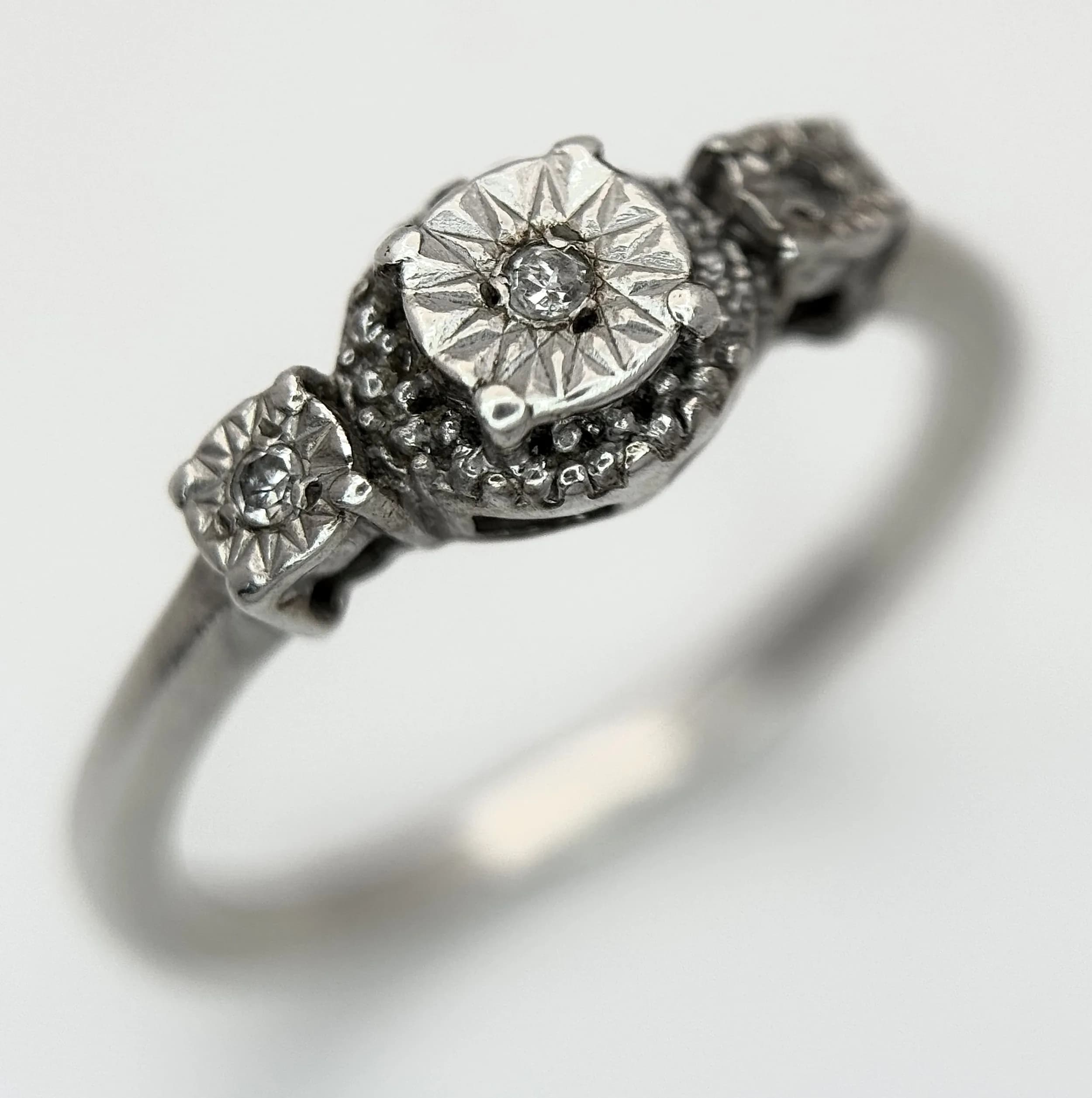 An Elegant, Art Deco Style, Silver (tested) Diamond Trilogy Ring. Size S. The Ring is set with three round cut Diamonds and has a gross weight of 2.54 grams.