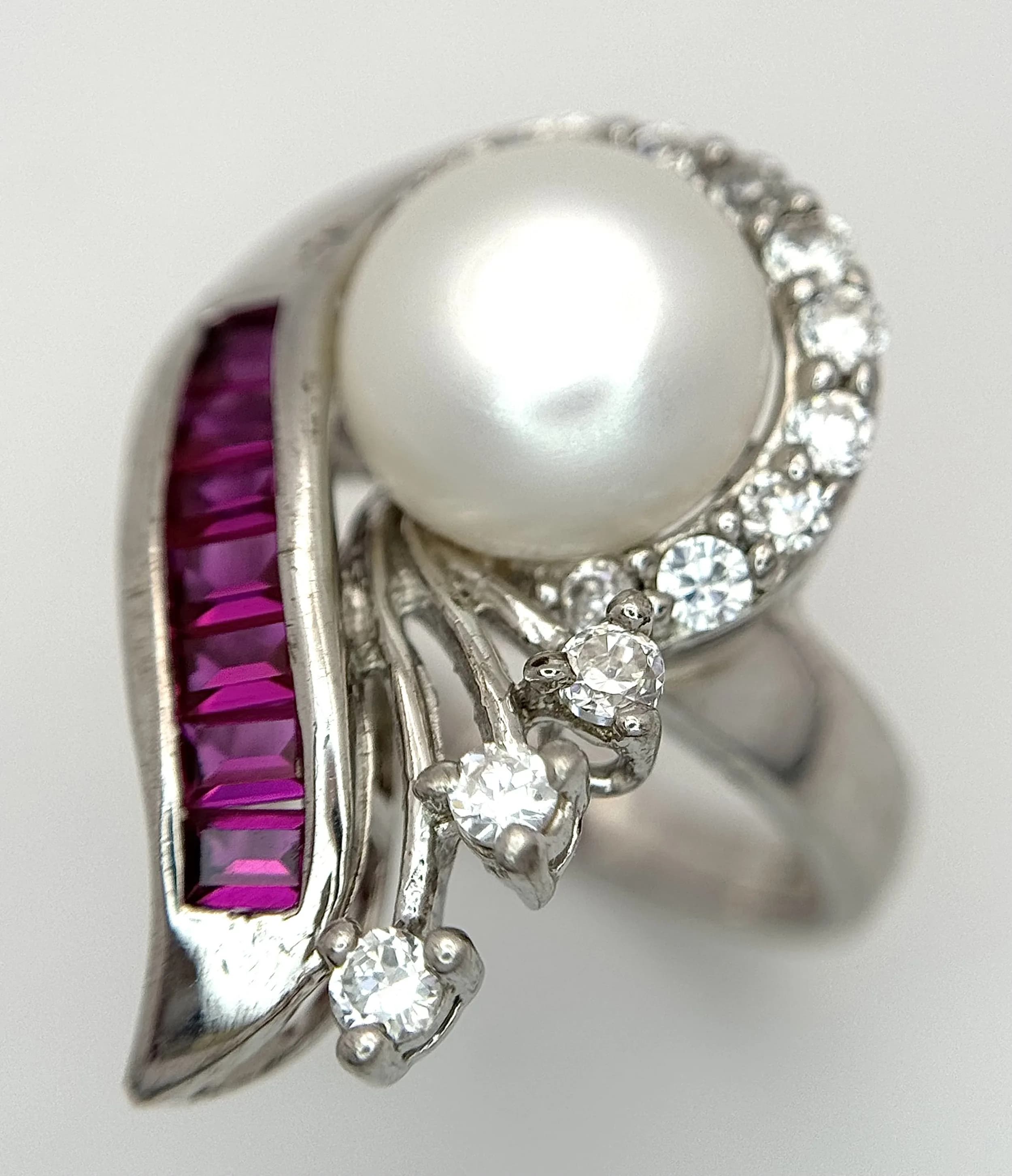 An Elegant Sterling Silver Abstract Design Pearl, Ruby and CZ Ring, Size L1/2. The Ring measures 2.5cm Length at the Crown and has a gross weight of 6.64 grams.