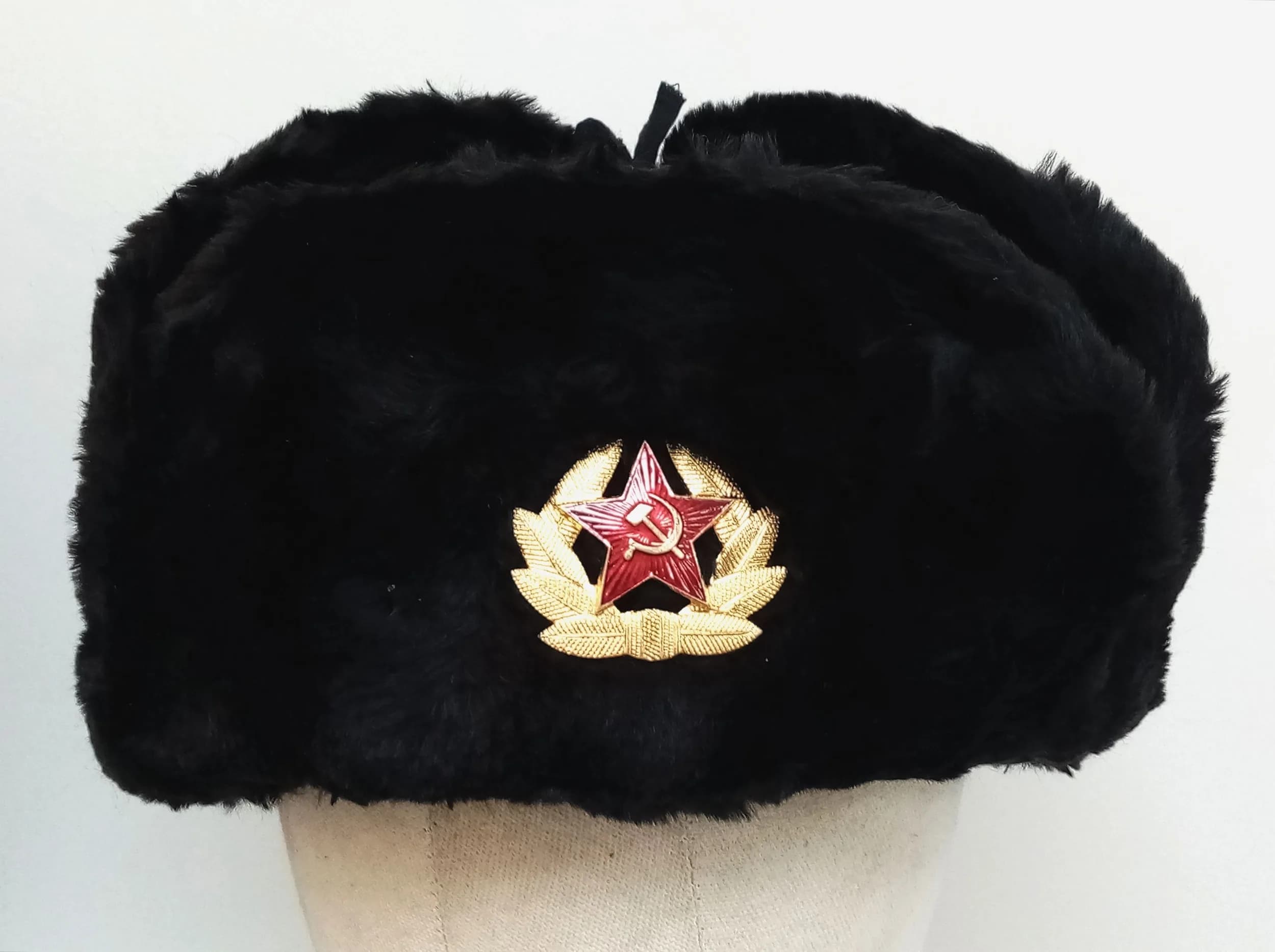 A Russian Navy/Submariner Style Winter Hat. Black faux fur ushanka style hat with red star hammer and sickle insignia. Size 64. Ear flaps can be worn down if required. Appears unworn.