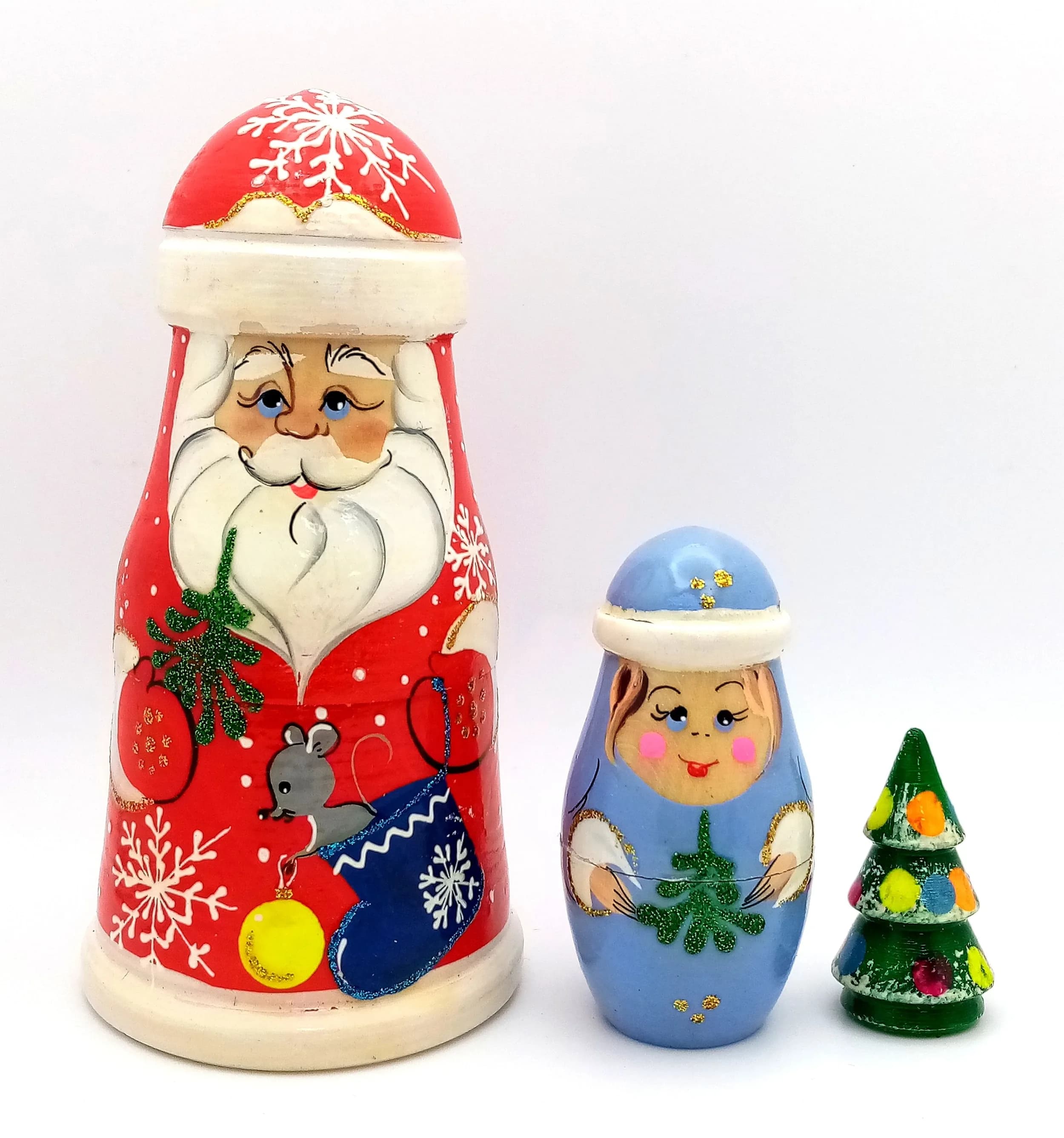A Santa Claus Style Russian Nesting Doll Set. Three-piece painted wooden nesting doll set featuring a festive Santa design. Made in Russia. Tallest doll measures 12cm. All dolls fit inside each other.