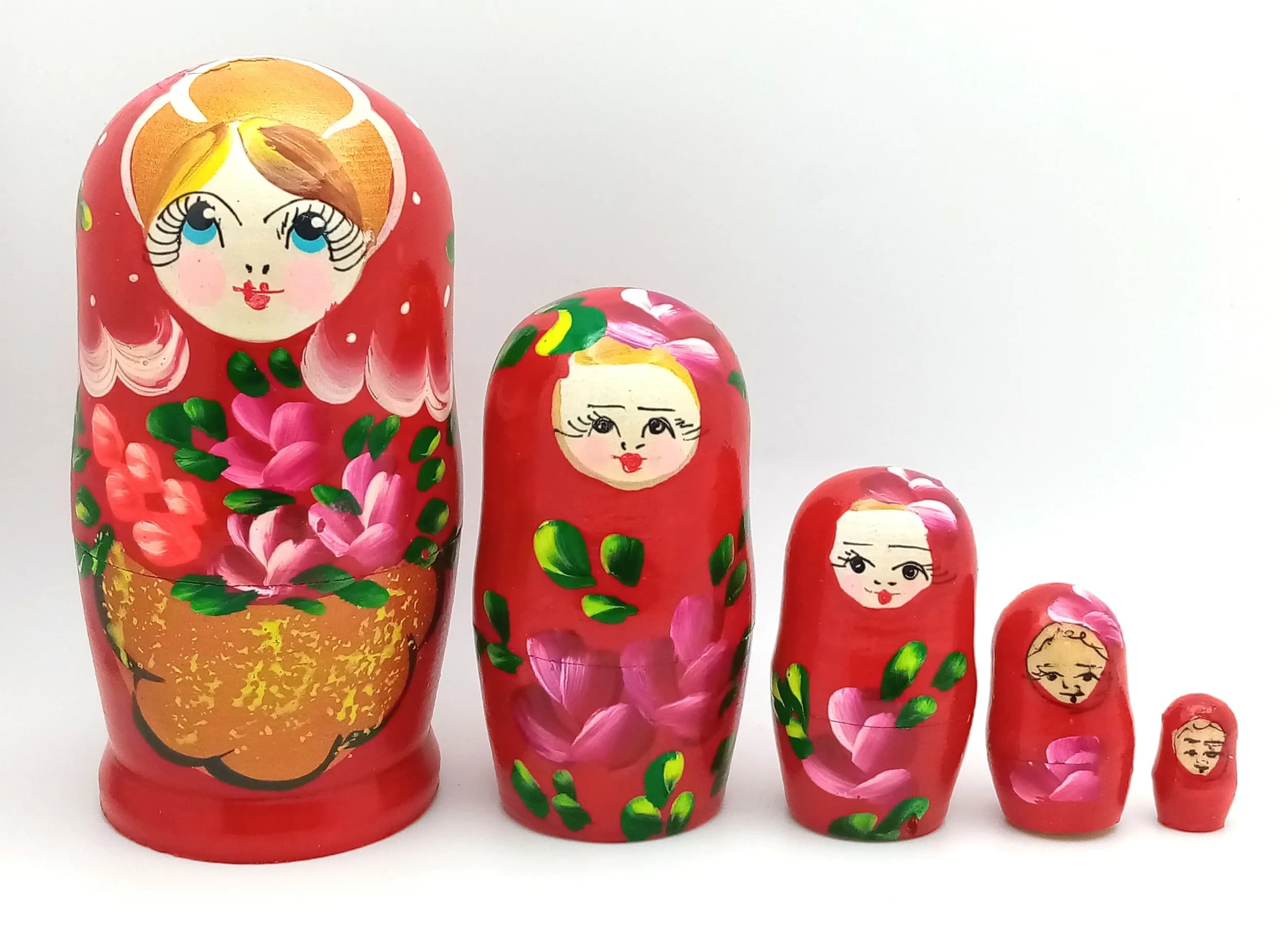 A Traditional Russian Nesting Doll Set. Five-piece hand-painted wooden nesting doll set featuring a classic floral design on a red ground. Handmade in Russia. Tallest doll measures 11cm. All dolls fit inside each other.