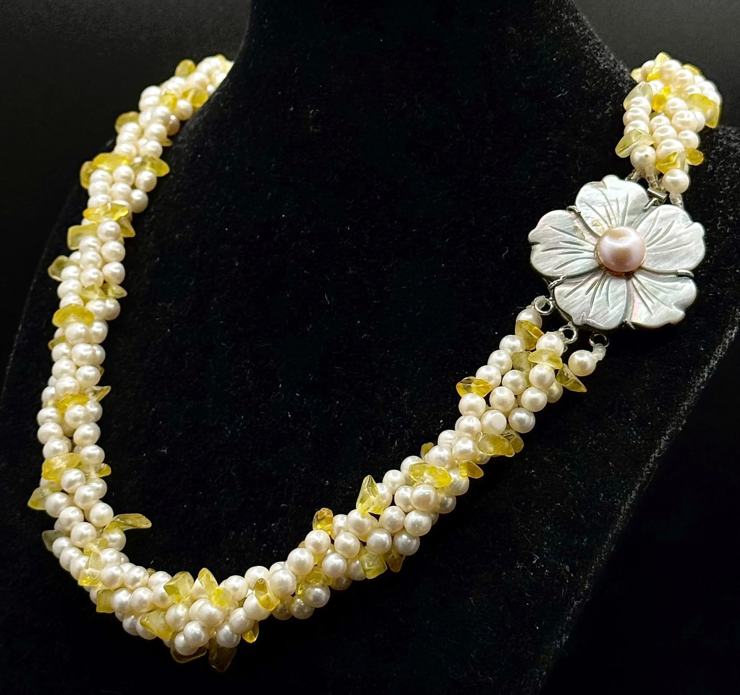 A Pretty Mother of Pearl Flower, Freshwater Pearl and Citrine Multi-Strand Necklace. Comprising four strands of freshwater pearls interspersed with citrine chips, with a carved mother of pearl flower clasp centred by a pink freshwater pearl. Approx 44cm length. Flower clasp measures approx 3.5cm x 3.5cm.