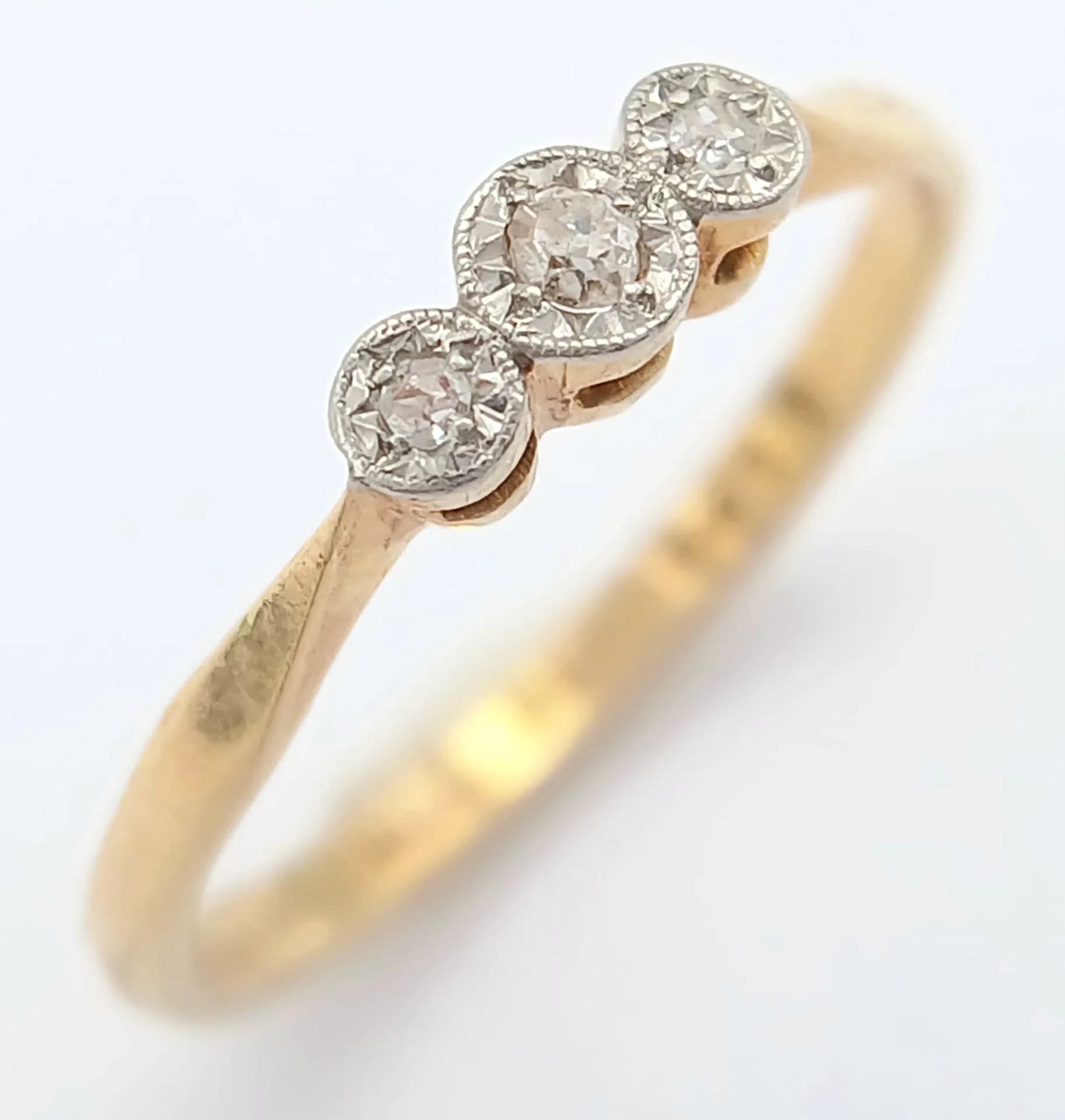 An 18K yellow gold diamond trilogy ring, 0.04ct diamond weight, 1.9g total weight, ring size M. Ref: SH10132H