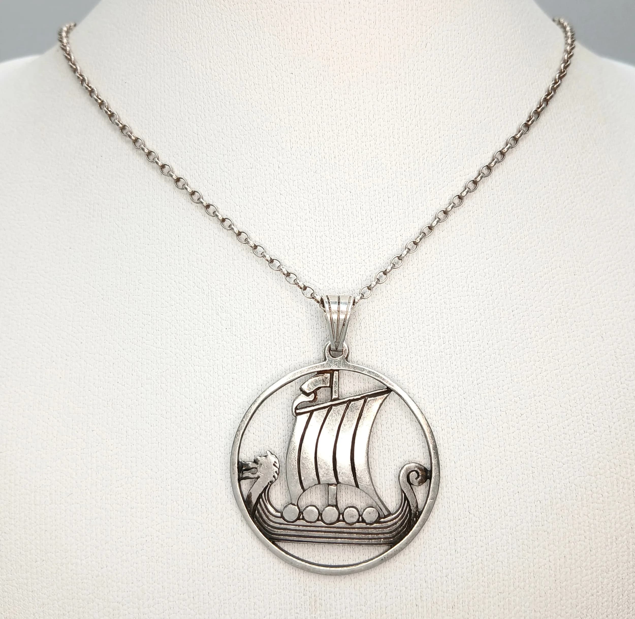 A Lovely Vintage Silver Viking Longship Pendant Necklace - 44cm Length. Features a circular openwork pendant depicting a Viking longship on a fine silver chain. The pendant measures 3cm diameter. Gross weight 6.48 grams.