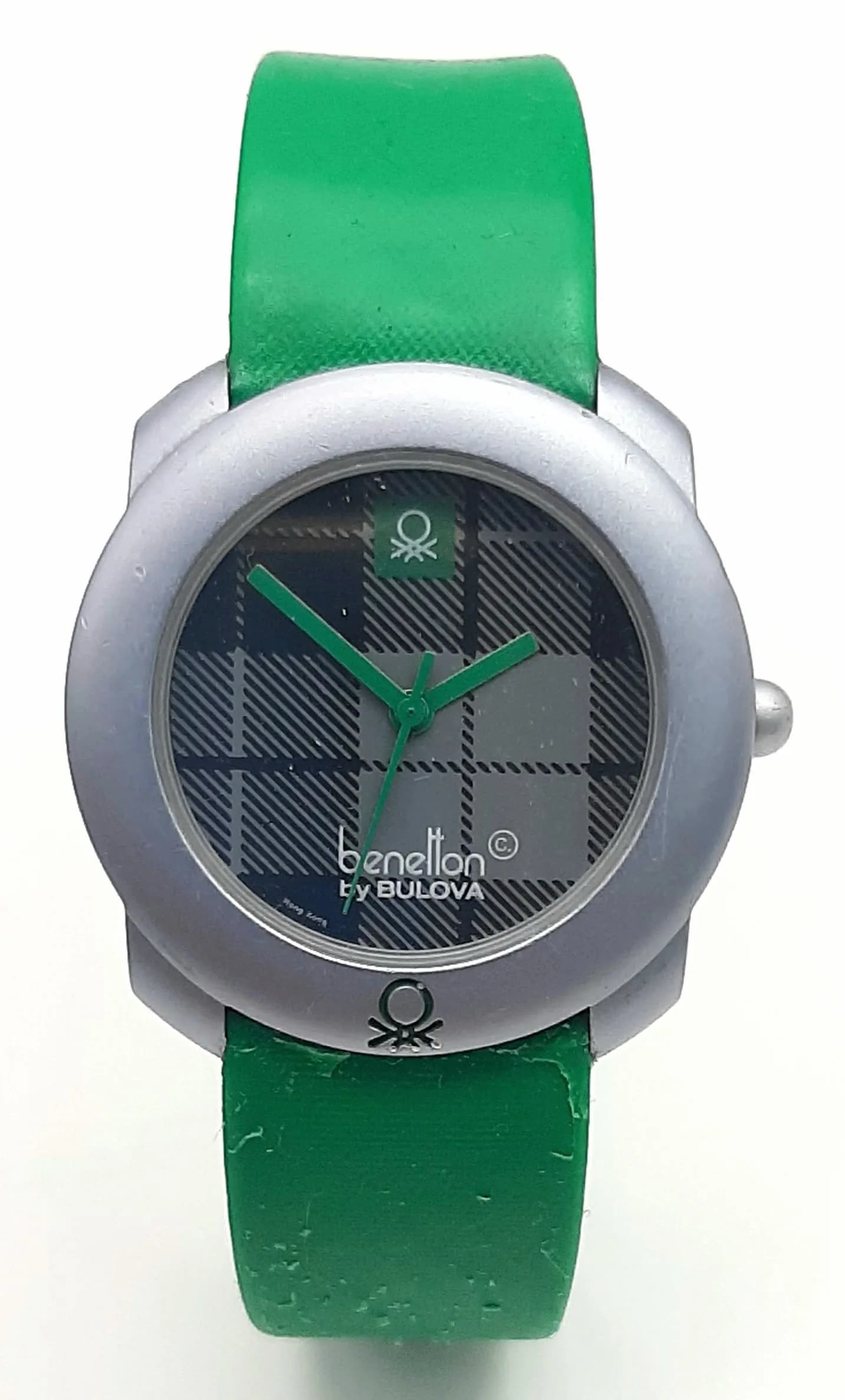 A UNITED COLORS OF BENETTON BY BULOVA, GREEN STRAP WATCH. ORIGINAL STRAP AND BUCKLE AND ORIGINAL PACKAGING. STRAP SECTION BY BUCKLE NEEDS ATTENTION. IN WORKING ORDER. S/A 1703 - 2